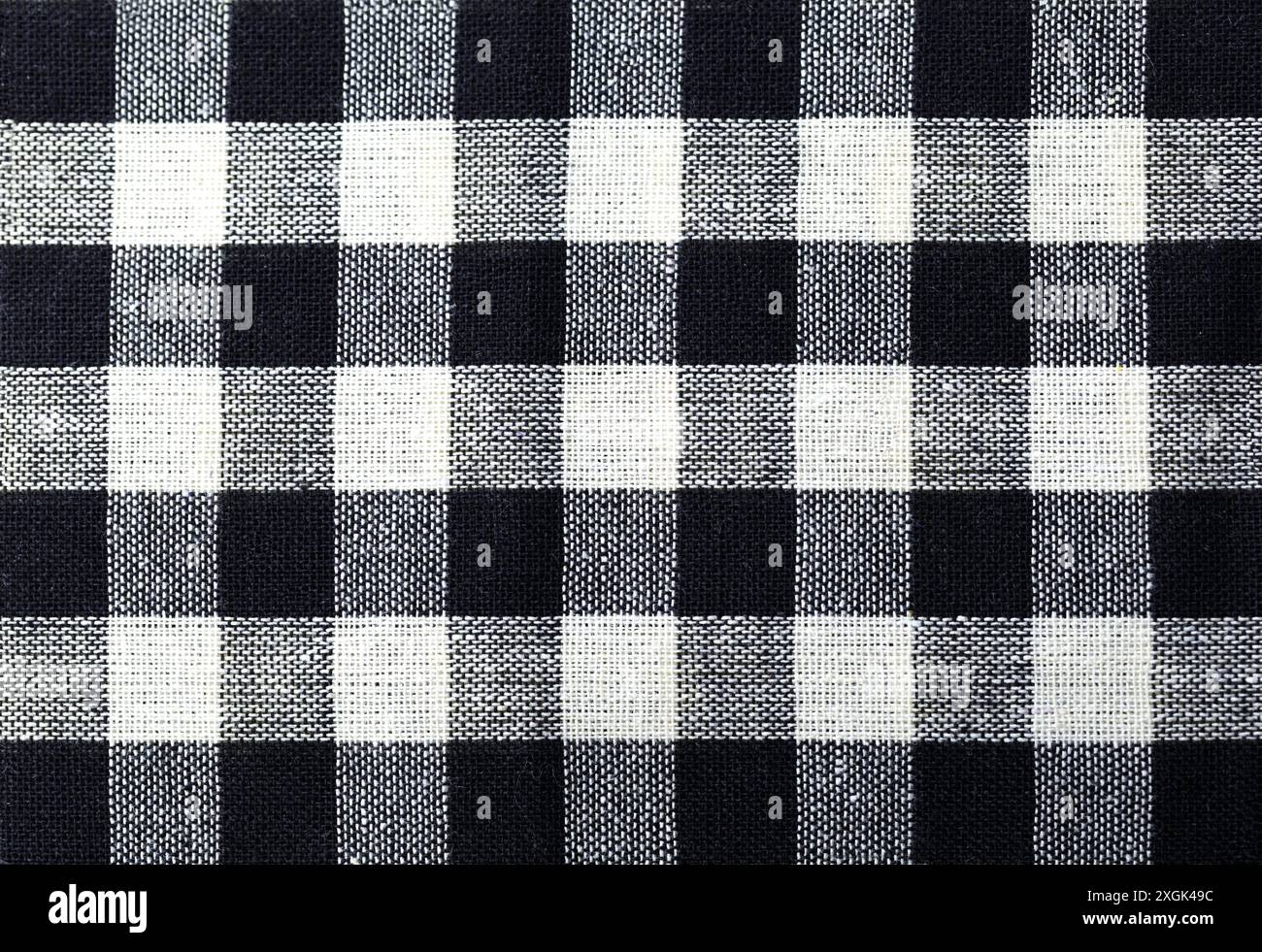 Gewebeprobe mit geometrischem Check-Muster in Schwarz und weiß. Der Stoff besteht aus einem gewebten Material. Stockfoto