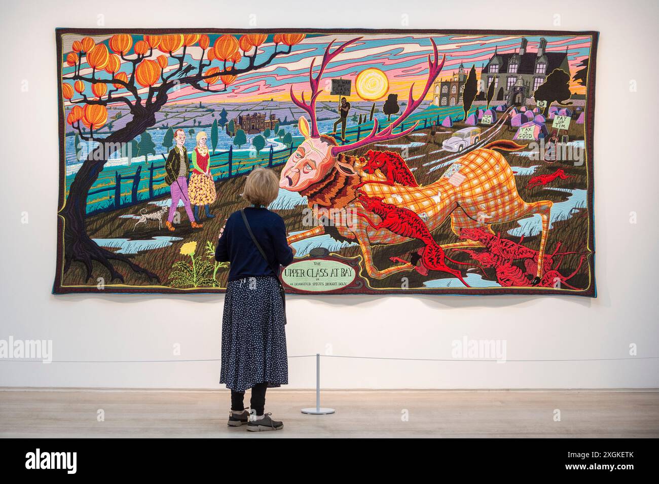 London, Großbritannien. 9. Juli 2024. Ein Mitarbeiter mit „The Upper Class at Bay“, 2012, bei einer Vorschau von „Grayson Perry: The Vanity of Small Differences“, 2012, einer neuen Ausstellung im Pitzhanger Manor & Gallery in Ealing, West London. Sechs großformatige Wandteppiche des mit dem Turner-Preis ausgezeichneten Künstlers, inspiriert von William Hogarths A Rake’s Progress (die Geschichte von Tom Rakewell im 18. Jahrhundert), sind zu sehen, wo Hogarths A Rake’s Progress vor 222 Jahren von Sir John Soanes Frau gekauft wurde, um in Pitzhanger ausgestellt zu werden. Die Ausstellung findet vom 10. Juli bis 8. Dezember 2024 statt. Quelle: Stephen Chu Stockfoto