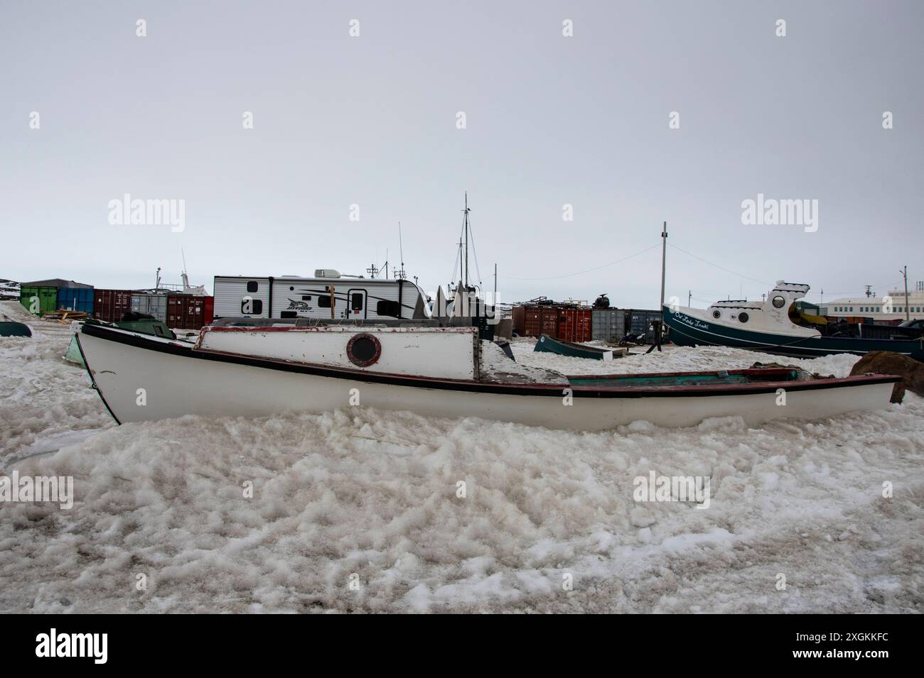Weißes Holzboot am Strand der Frobisher Bay in Iqaluit, Nunavut, Kanada Stockfoto
