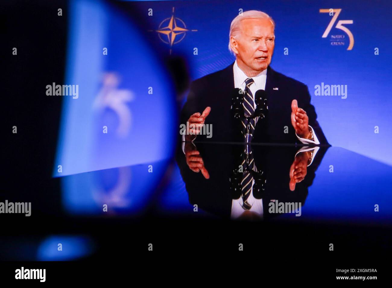 In dieser Fotoabbildung zeigt ein Bildschirm den derzeitigen US-Präsidenten Joe Biden während seiner Rede bei der Eröffnungszeremonie des NATO-Gipfels zum 75. Jahrestag. Das 75. Gipfeltreffen der Nordatlantischen Vertragsorganisation (NATO) fand in der Hauptstadt der Vereinigten Staaten von Amerika, Washington, statt. Dies ist eine jährliche Veranstaltung, bei der sich führende Vertreter der Mitgliedsländer der Allianz treffen, um aktuelle Fragen der Sicherheit und Zusammenarbeit zu erörtern. Die NATO betrachtet den "Sieg Russlands in der Ukraine" als ihr größtes Risiko das Ergebnis dieses Konflikts wird das globale Sicherheitssystem für Jahrzehnte bestimmen, sagte Jens Stoltenberg. Während c Stockfoto