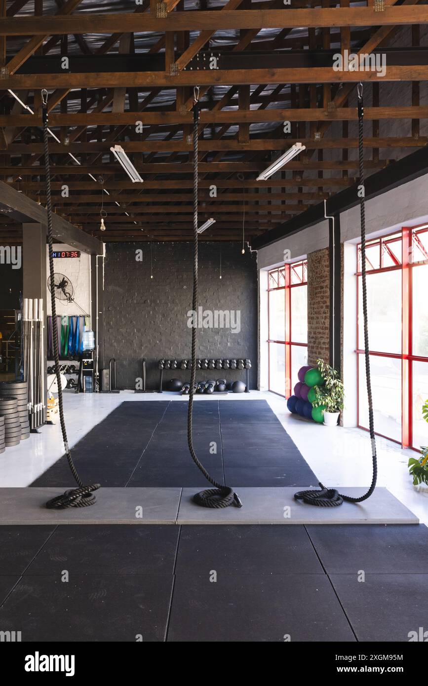 Im gut ausgestatteten Fitnessraum gibt es verschiedene Fitnessgeräte. Der Raum ist für funktionelles Training mit Seilen, Gewichten und Trainingsball ausgelegt Stockfoto