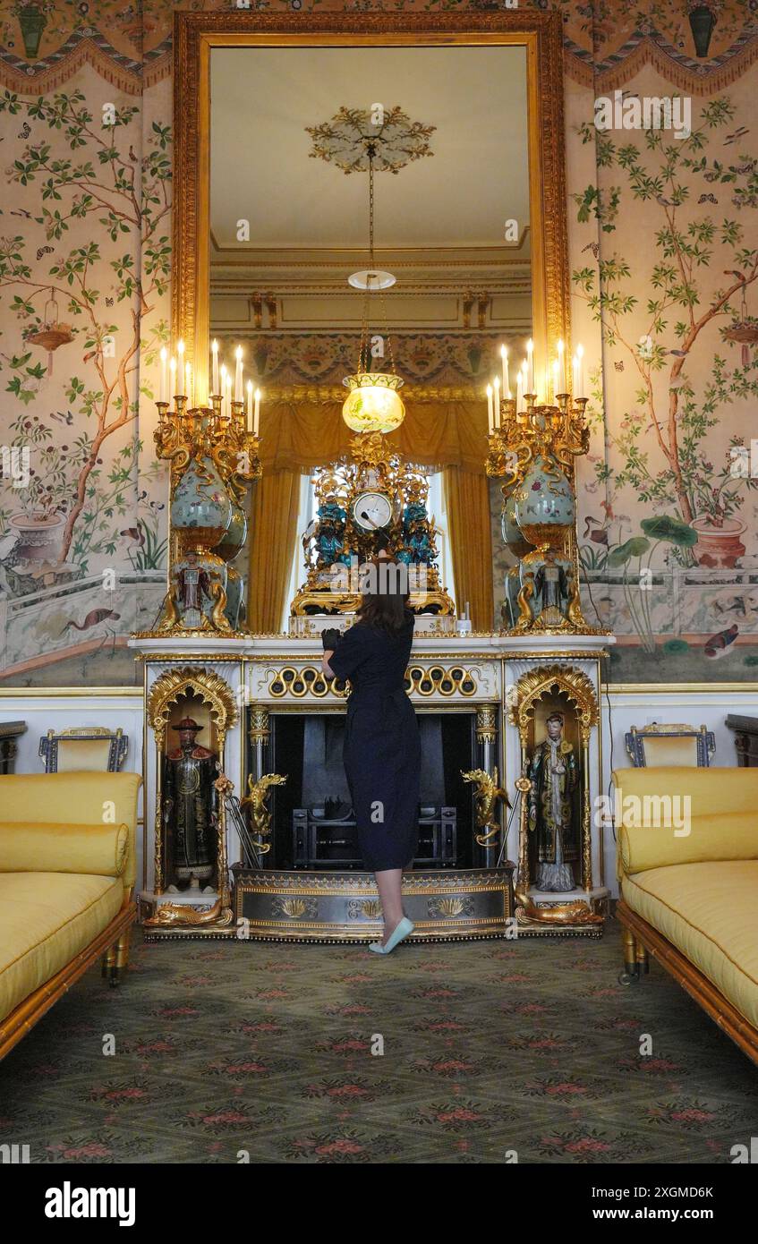 Die letzten Vorbereitungen werden im Yellow Drawing Room getroffen, wo ein Mitglied des Royal Collection Trust die Kylin Uhr betreut, im Ostflügel des Buckingham Palace, London. die erstmals in diesem Sommer für Besucher geöffnet wird, wenn im Juli und August spezielle Führungen durch die Hauptetage angeboten werden. Bilddatum: Montag, 8. Juli 2024. Stockfoto