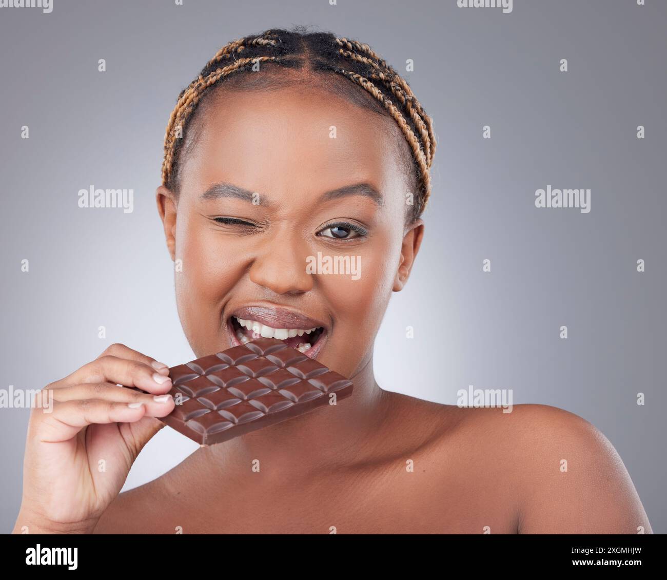 Schwarze Frau, Porträt und eine dunkle Schokolade im Studio mit Hautpflege, Schönheit und Antioxidantien essen. Model-, Person- und Deckenkuchen für Cheat-Mahl, süß Stockfoto