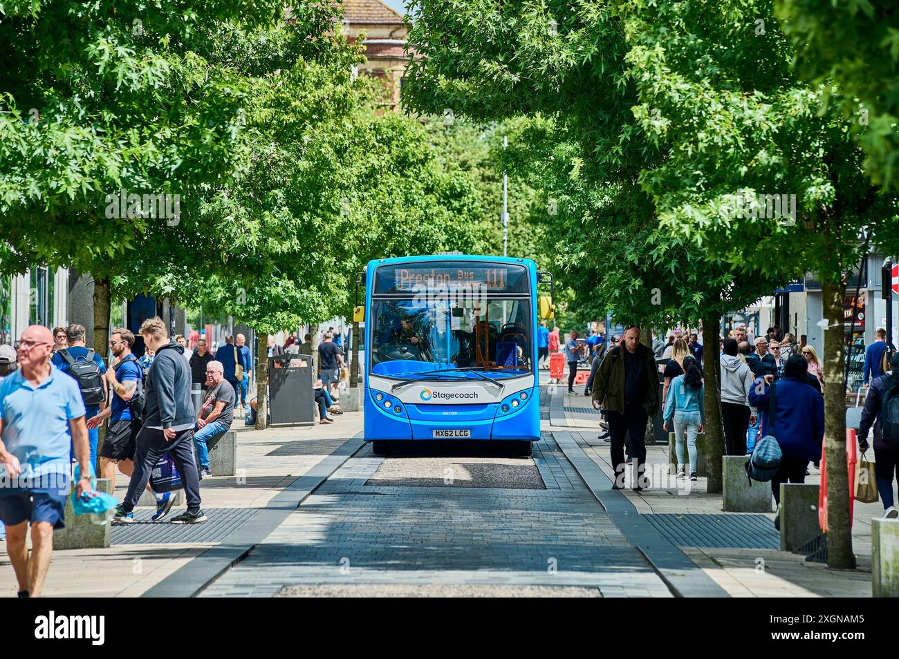 Busfahrt durch ein baumgesäumtes Fishergate im Stadtzentrum von Preston Stockfoto