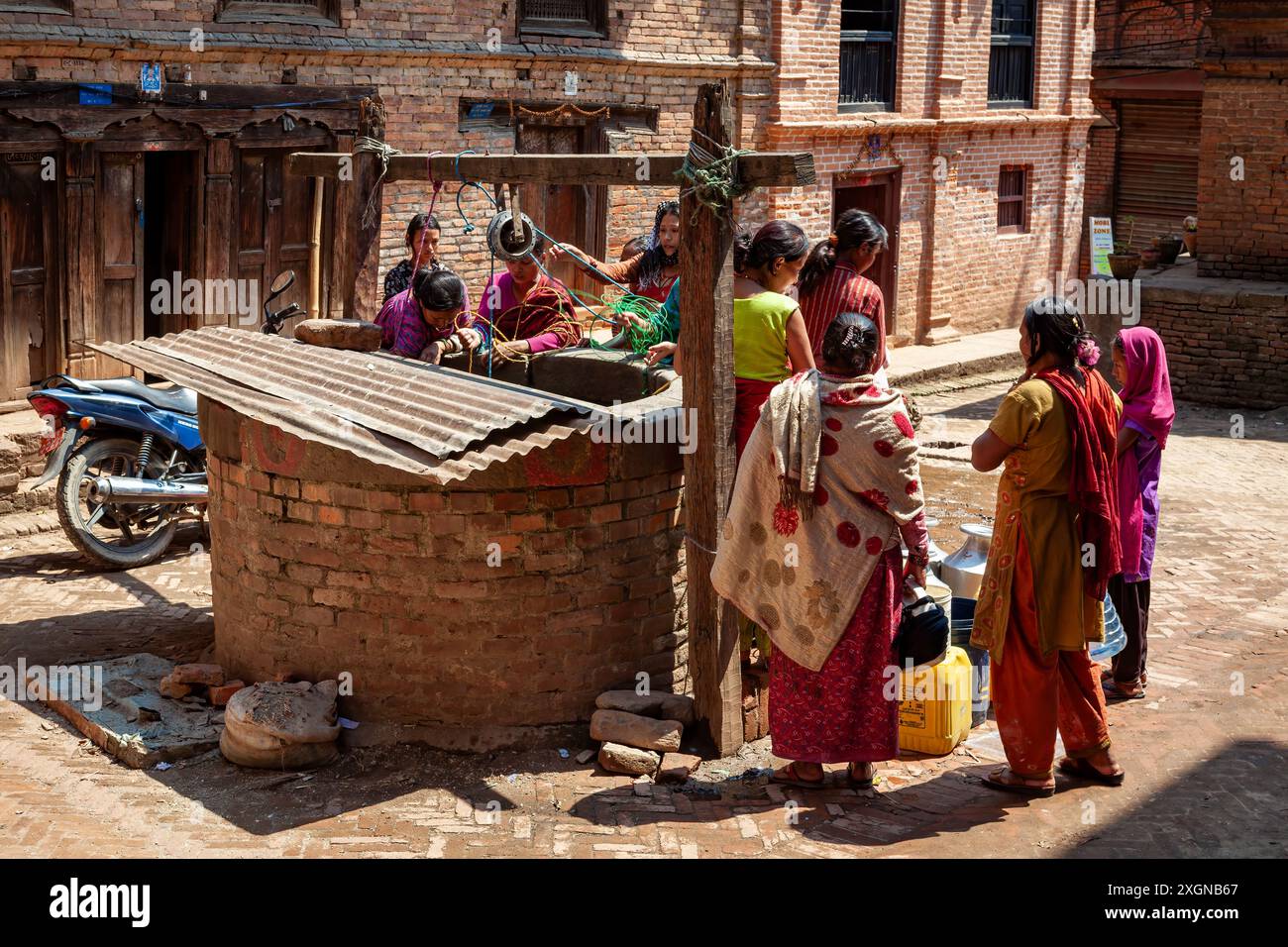 Frauen holen Wasser aus dem Brunnen in Bhaktapur Stockfoto