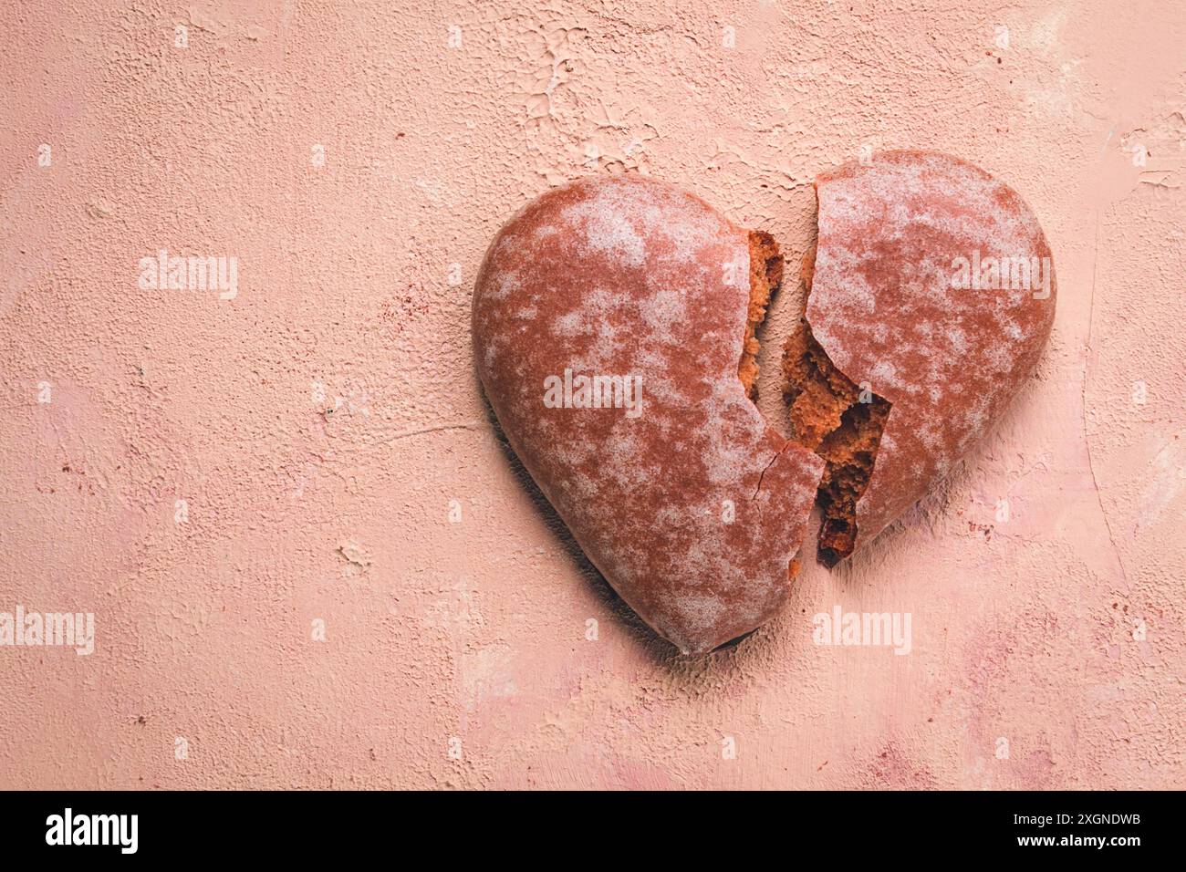 Glasierter Schokoladen-Lebkuchen, Herzform, Draufsicht, gebrochenes Herz, Nahaufnahme, auf beigefarbenem Hintergrund, keine Leute Stockfoto