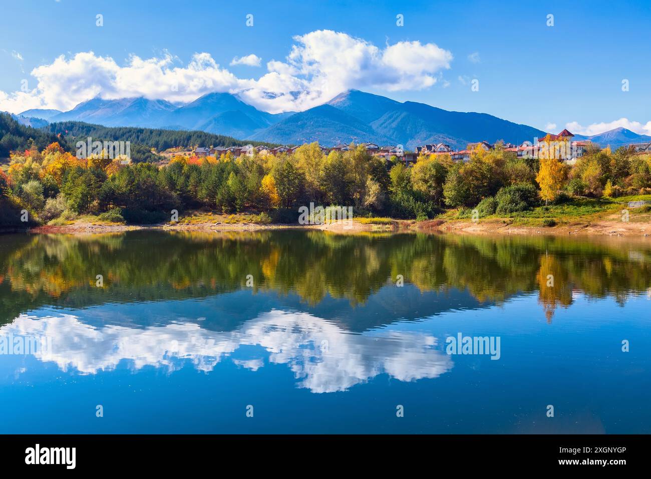 Bansko, Bulgarien Herbst Panorama Hintergrund der Pirin Berggipfel, Wasser See, bunte grüne, rote und gelbe Bäume Reflexion Stockfoto