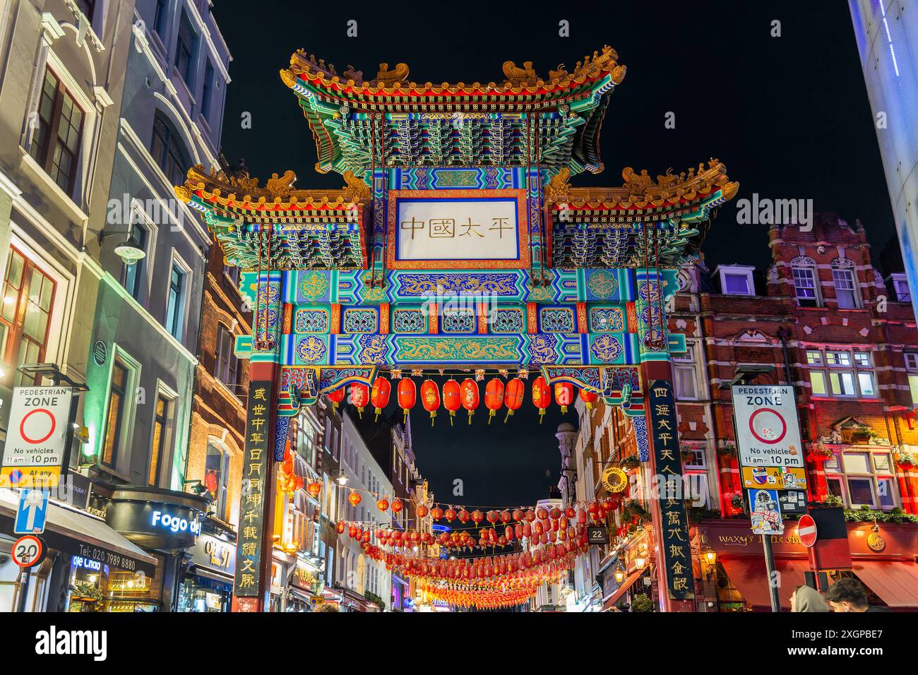 Buntes Tor und rote chinesische Laternen in der Gerrard Street, Chinatown bei Nacht in London, Großbritannien Stockfoto