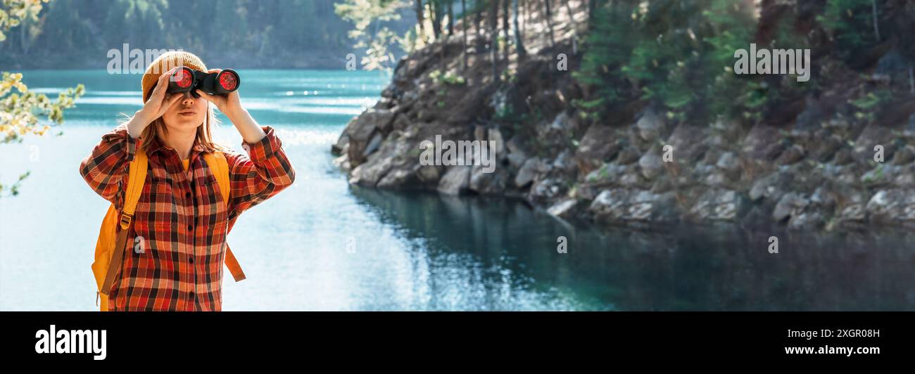 Junge Frau Ökologin oder Wildtiermanagerin mit Fernglas am Ufer eines Sees Vögel beobachten Banner Kopierraum Forschung in der Natur, Beobachtung von A Stockfoto