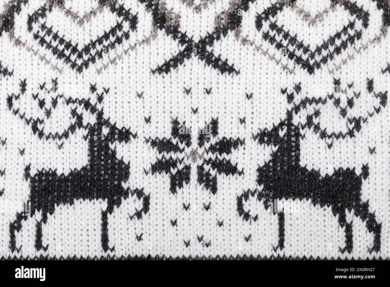 Nahaufnahme eines weißen Strickpullovers mit schwarzem Rentier und Schneeflocke Stockfoto