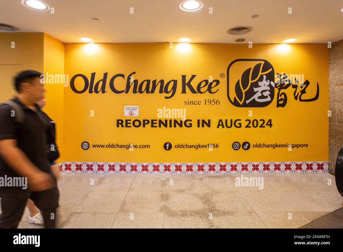Die Leute gehen am Old Chang Kee Shop vorbei, der gerade renoviert wird. Es zeigt sogar, wo man auf der Website und in sozialen Medien zu finden ist TikTok, Facebook. Singapur. Stockfoto