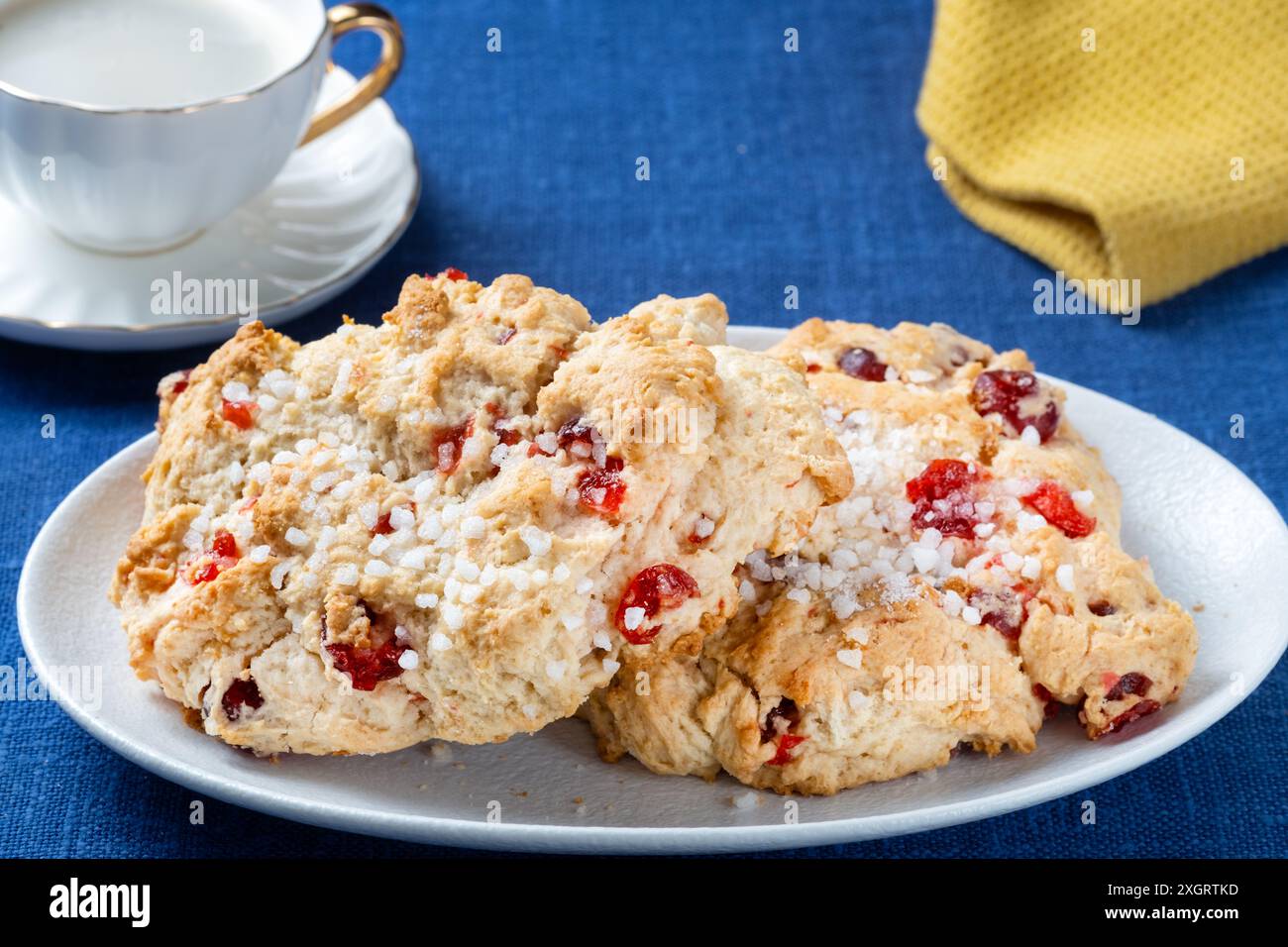 Zwei frische traditionelle große, englische Kirschtorten serviert mit einer Tasse schwarzen Kaffee. Die Kuchen sind auf einem einfachen Tischtuch überzogen Stockfoto