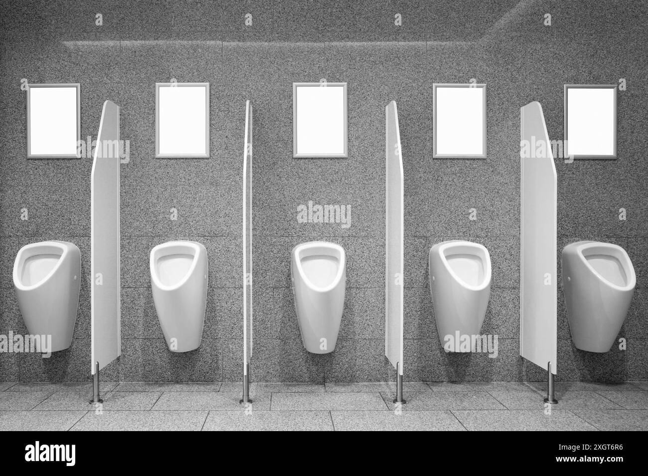 Eine Gruppe weißer Werbeplakate, die an der Wand neben den Urinalen in der Herren-Toilette hängen Stockfoto