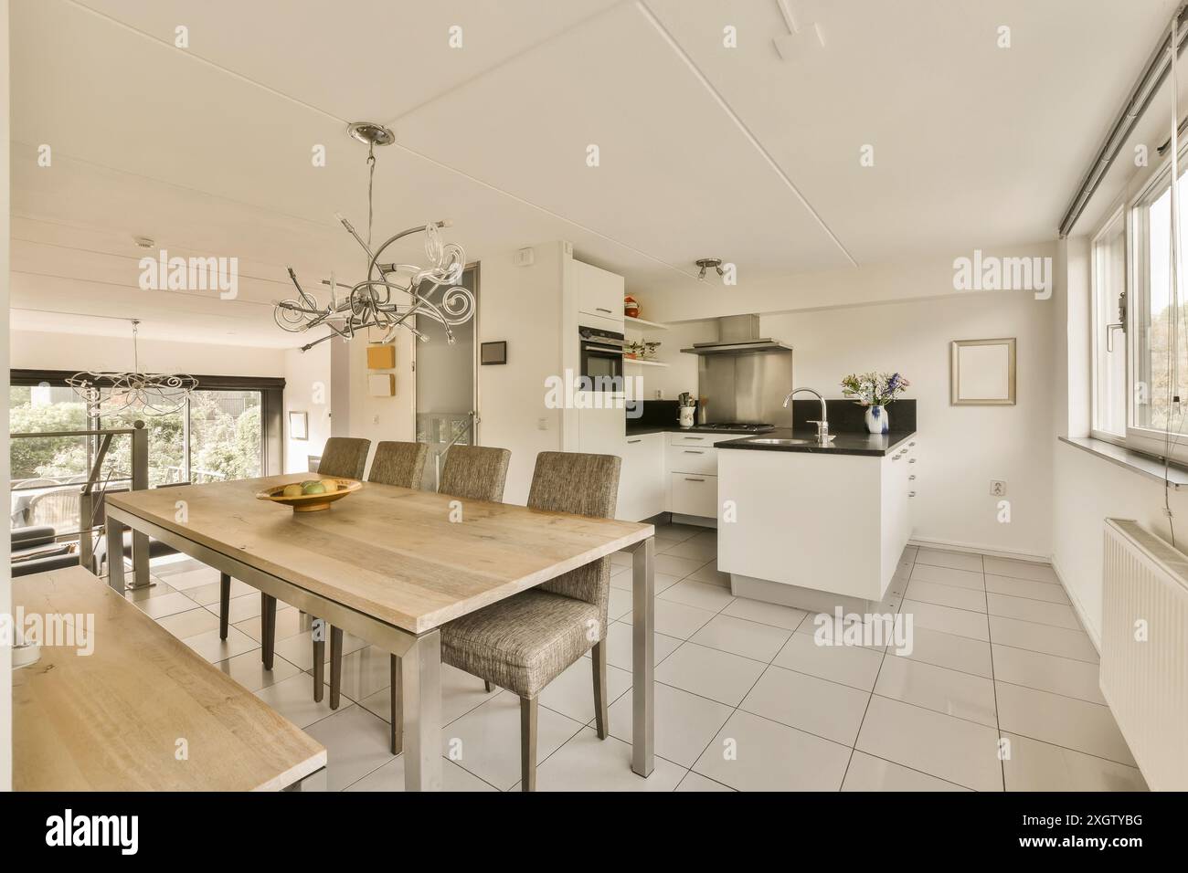 Helle, luftige Küche mit elegantem weißem Design, einem modernen Esstisch und stilvollen Leuchten in der Herentalsstraat, Amsterdam Stockfoto