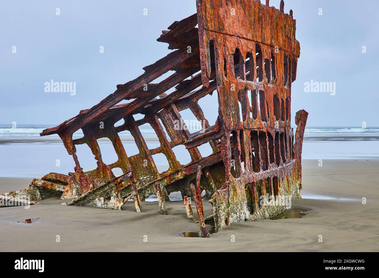 Verrostetes Schiffswrack am Sandstrand vor dem Hintergrund des Ozeans - Perspektive auf Augenhöhe Stockfoto