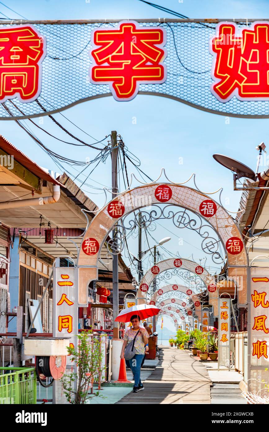 Penang, Malasien-April 30 2023: Dieser kunstvoll verzierte Clan Jetty, dekoriert mit chinesischen Symbolen und gesäumt von Geschäften und Restaurants, ist auf Stelzen gebaut, am Rande von Stockfoto