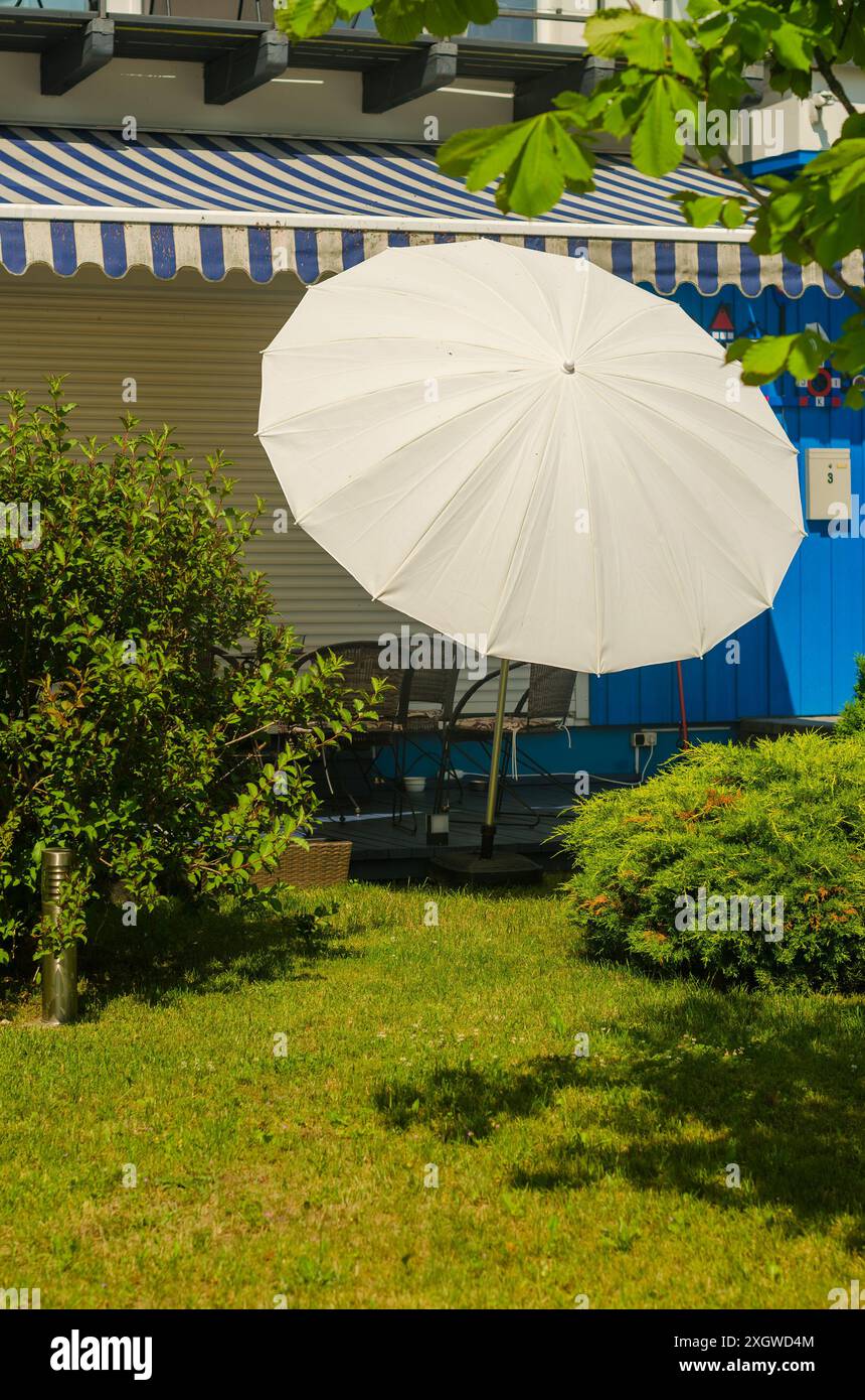Das Haus mit weißem Sonnenschirm auf der Terrasse. Hochwertige Fotos Stockfoto