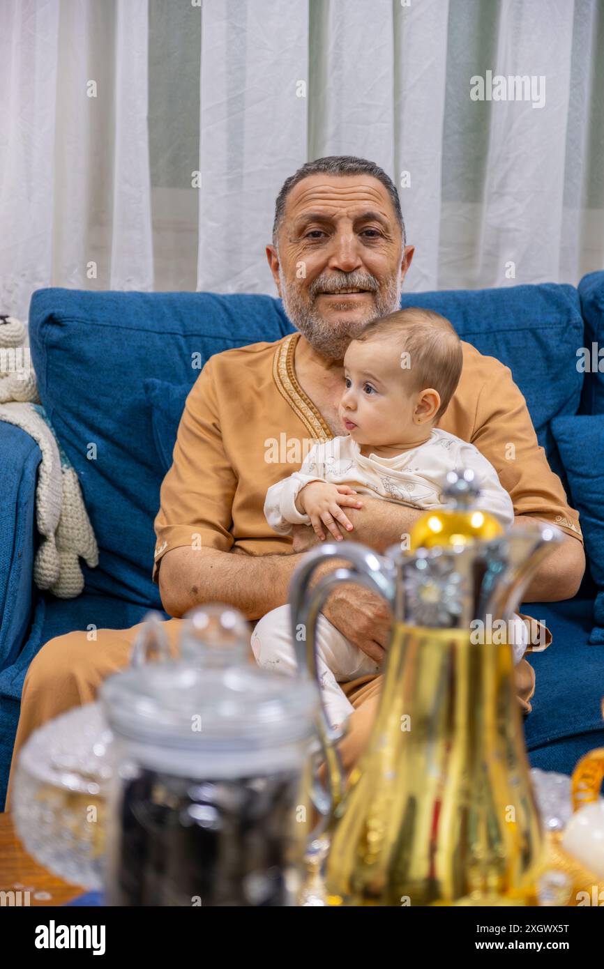 Opa und Enkelin halten sie im Wohnzimmer mit kawaii-Lächeln Stockfoto