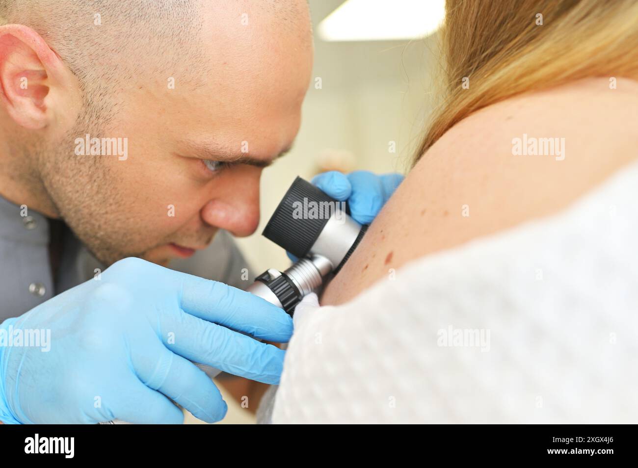 Der Dermatologe Onkologe verwendet ein Dermatoskop, um Muttermale und