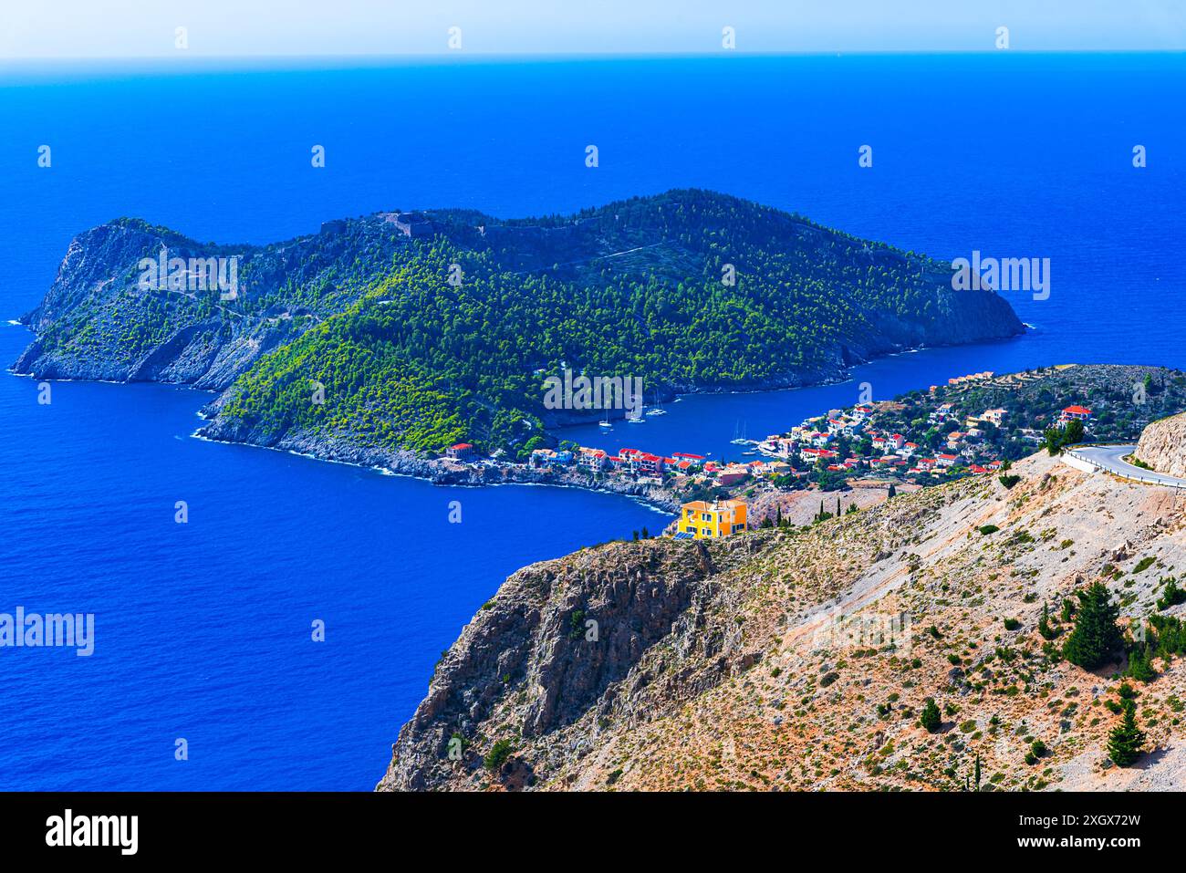 Assos, Kefalonia, Griechenland. Überblick über die türkisfarbene Bucht und die farbenfrohe Stadt auf einer idyllischen Ionischen Insel. Reiseziel Europa Stockfoto