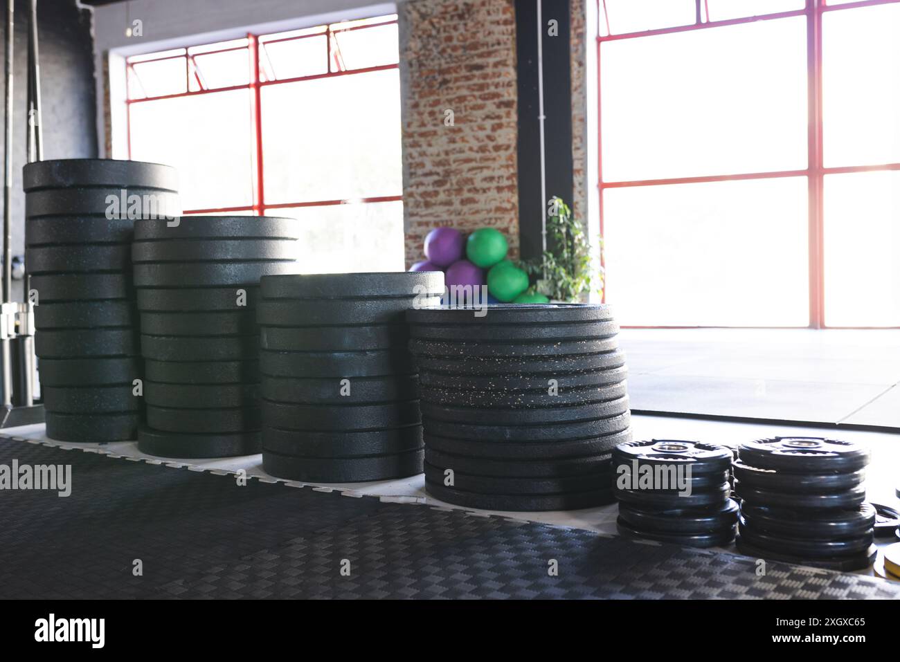 Die Fitnessgeräte sind ordentlich in einem Fitnesscenter untergebracht, das unverändert ist. Verschiedene Gewichte und Übungsbälle bieten einen vielseitigen Trainingsraum für Krafttraining Stockfoto