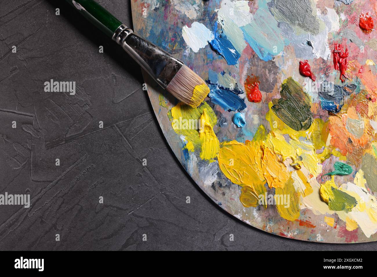 Künstlerpalette, Pinsel und Farben auf grauem Tisch, Draufsicht. Leerzeichen für Text Stockfoto