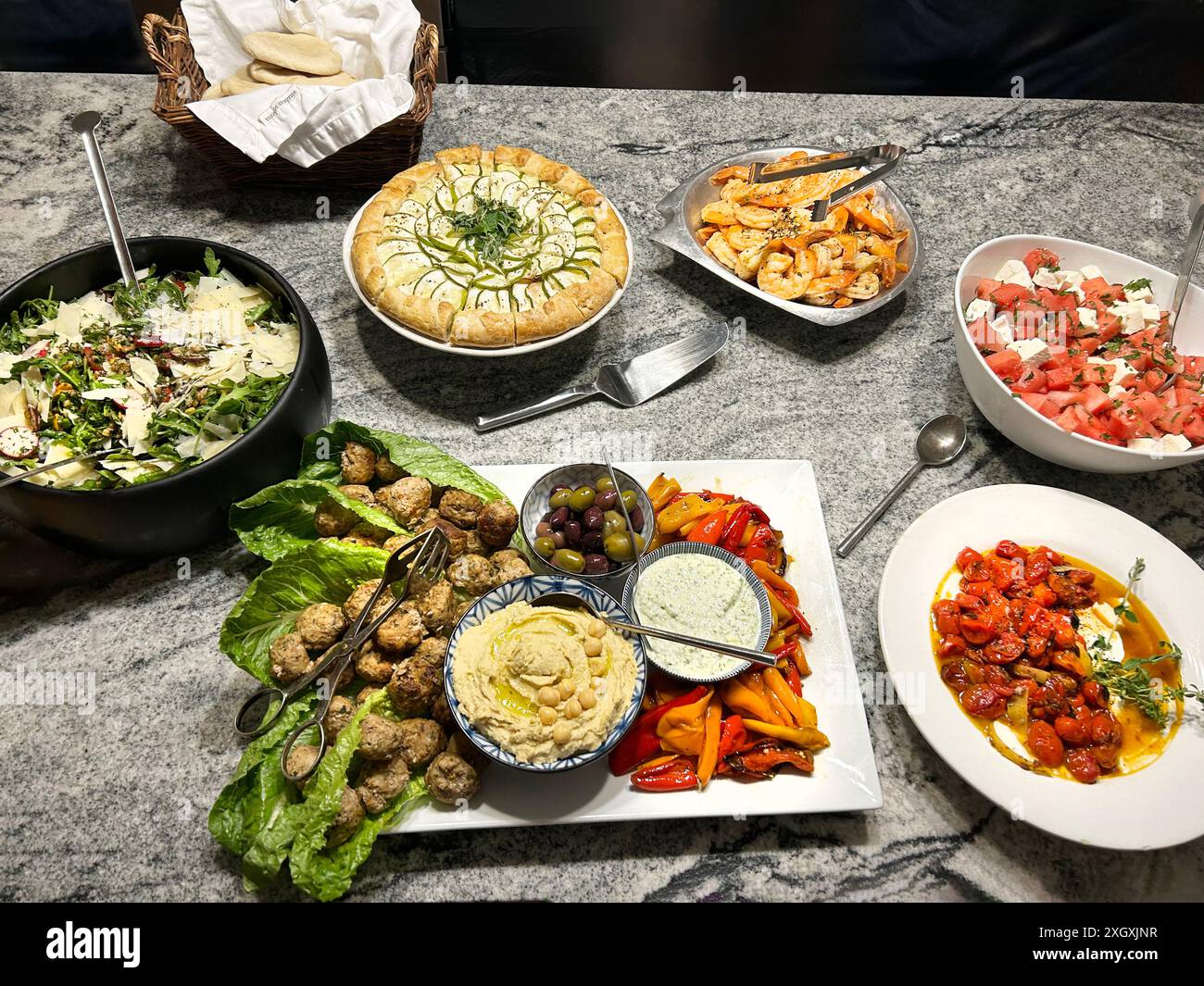 Rucola-, Farro- und Kräutersalat, geröstete Tomaten mit herzhaftem Joghurt, Feta-Salat, gegrillte Garnelen und Mezze-Platte Stockfoto