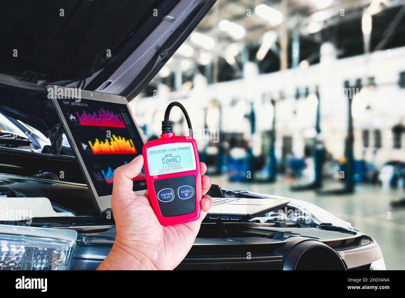 OBD2- oder OBD-Scanner und Laptop für die Motorsystemanalyse bis zur Reparatur des Motorsystems in der Kfz-Werkstatt , Servicekonzept für die Fahrzeugwartung Stockfoto