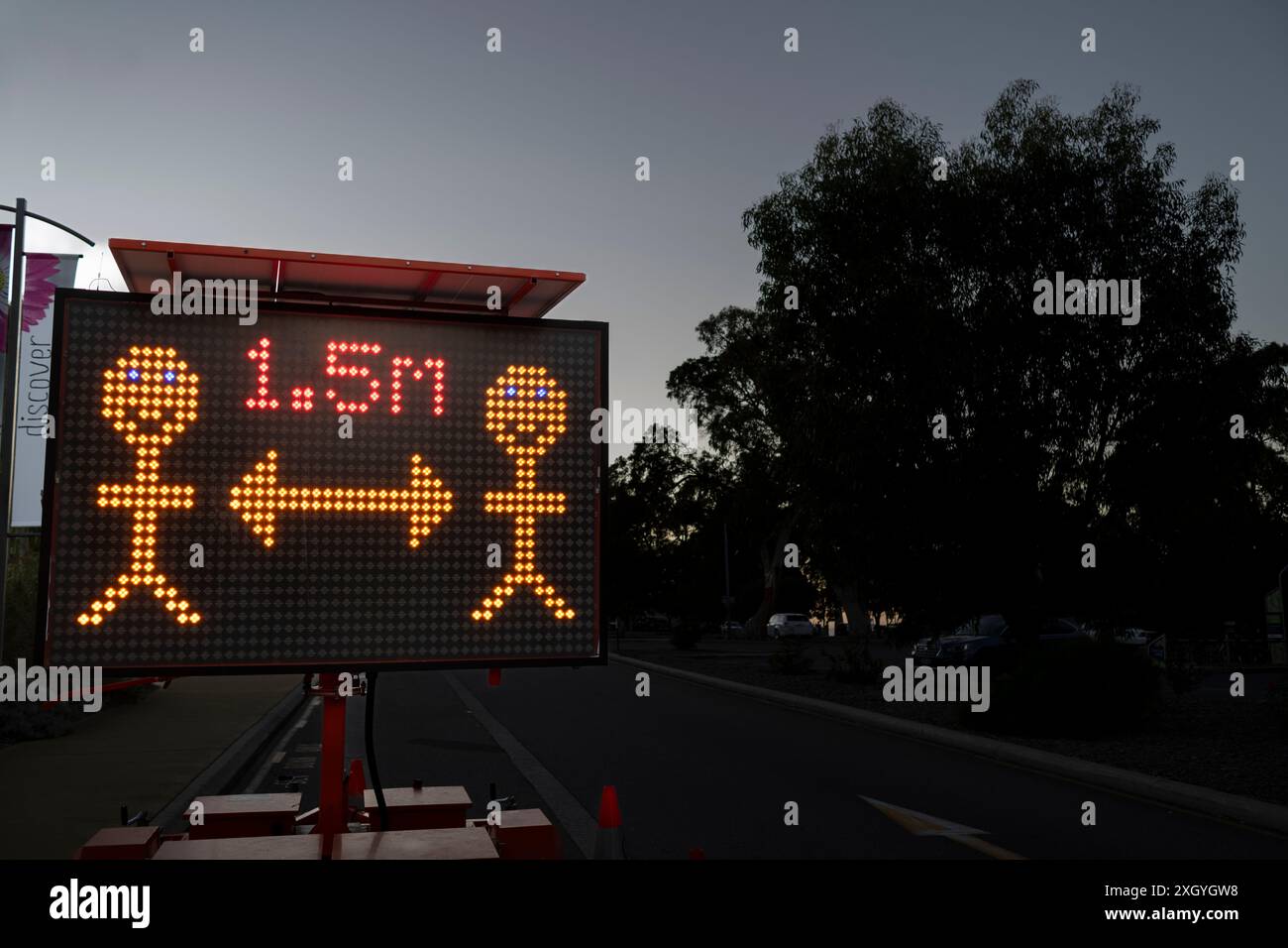 Ein elektronisches Straßenschild, das während der covid verwendet wird, um die Menschen daran zu erinnern, sich zu distanzieren. Stockfoto