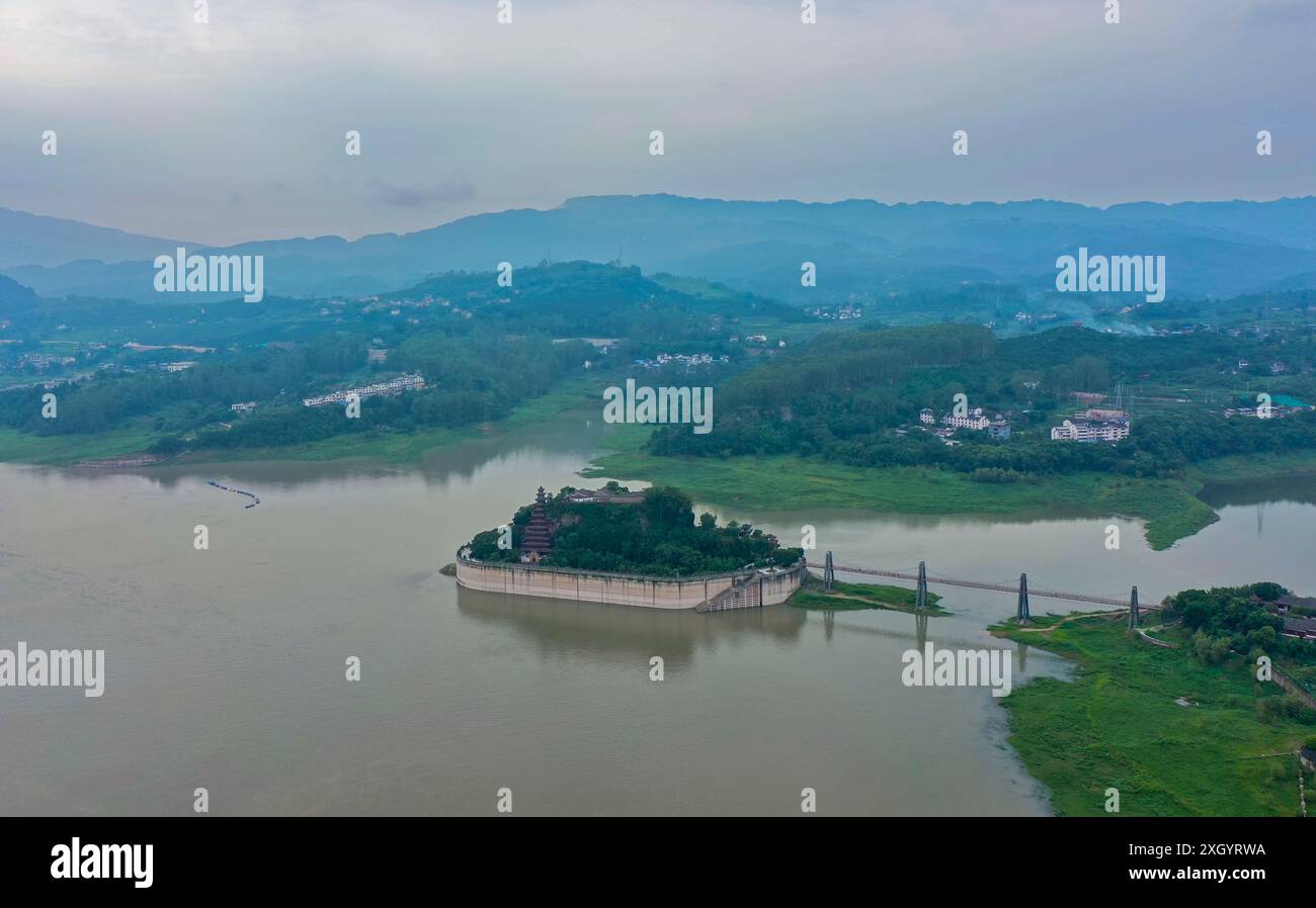 Chongqing. Juli 2024. Ein Drohnenfoto vom 10. Juli 2024 zeigt Shibaozhai, einen malerischen Ort im Zhongxian County im Südwesten Chinas in Chongqing. Shibaozhai sieht aus wie ein herzförmiger Bonsai, der mitten im Abschnitt der drei Schluchten von Yangtse Rier sitzt. Hier befindet sich eine 12-stöckige, 56 Meter hohe Holzpagode, die auf 20 Säulen steht und sich gegen die Klippe neigt. Dieses Gebäude stammt aus der Ming-Dynastie (1368–1644) und ist eine der wichtigsten Touristenattraktionen von Shibaozhai. Quelle: Liu Chan/Xinhua/Alamy Live News Stockfoto