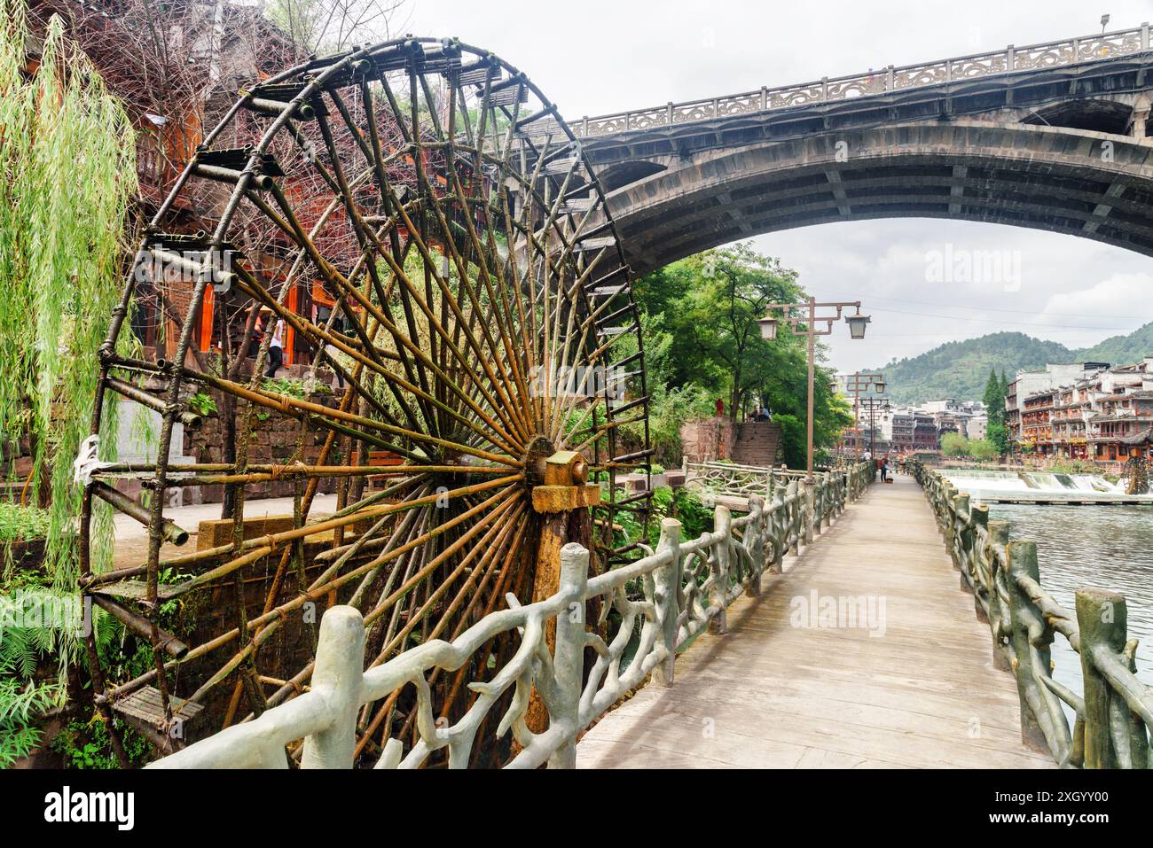 Malerisches Wasserrad und Brücke über den Tuojiang Fluss (Tuo Jiang Fluss) in Phoenix Ancient Town (Fenghuang County), China. Stockfoto