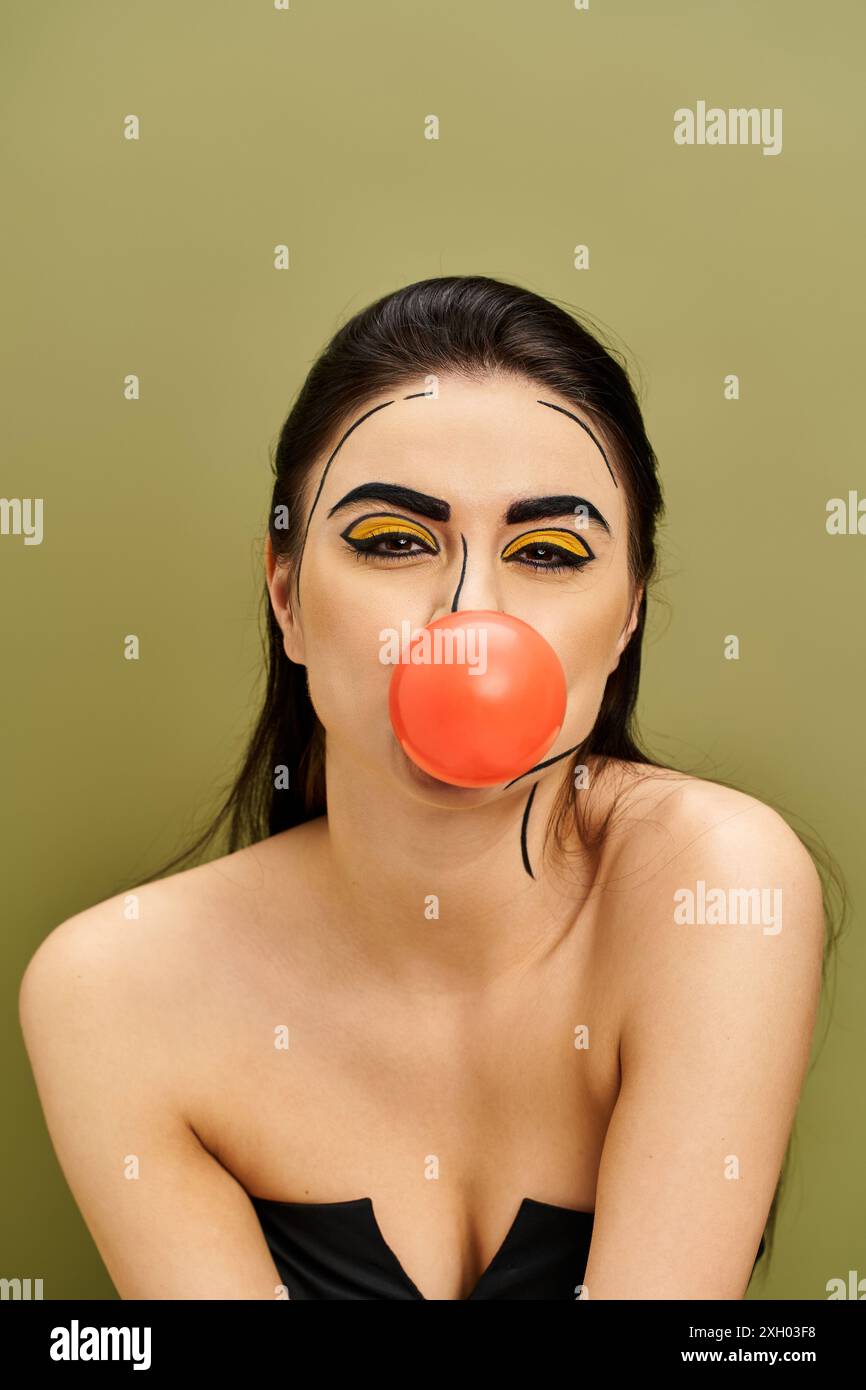 Brünette Frau mit Pop-Art-Make-up, das Kaugummi bläst Stockfoto