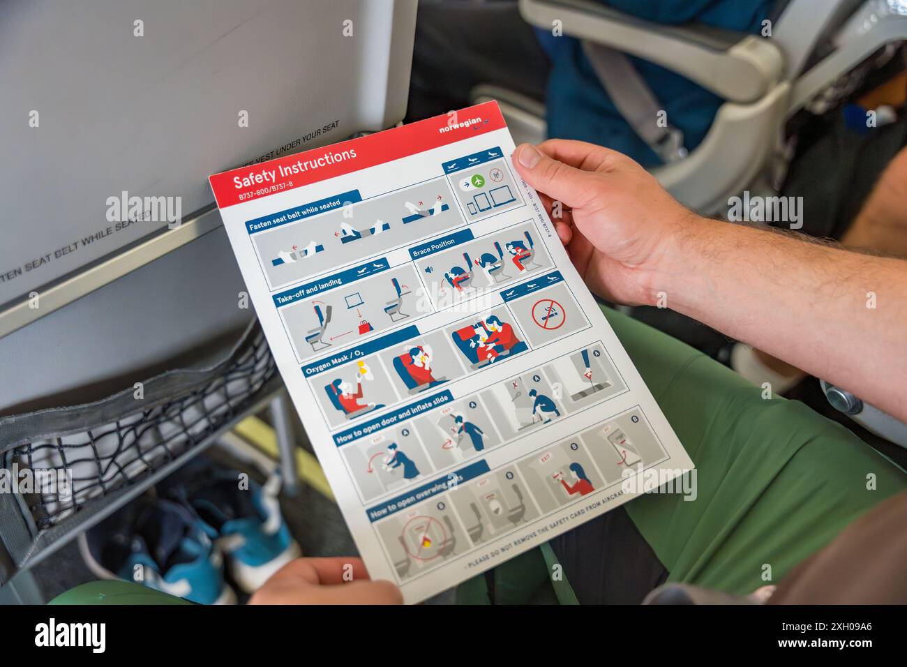Prag, Tschechische Republik - 5. Juli 2024: Lesen der Sicherheitsanweisungen auf einem Flug der Norwegian Airlines Stockfoto