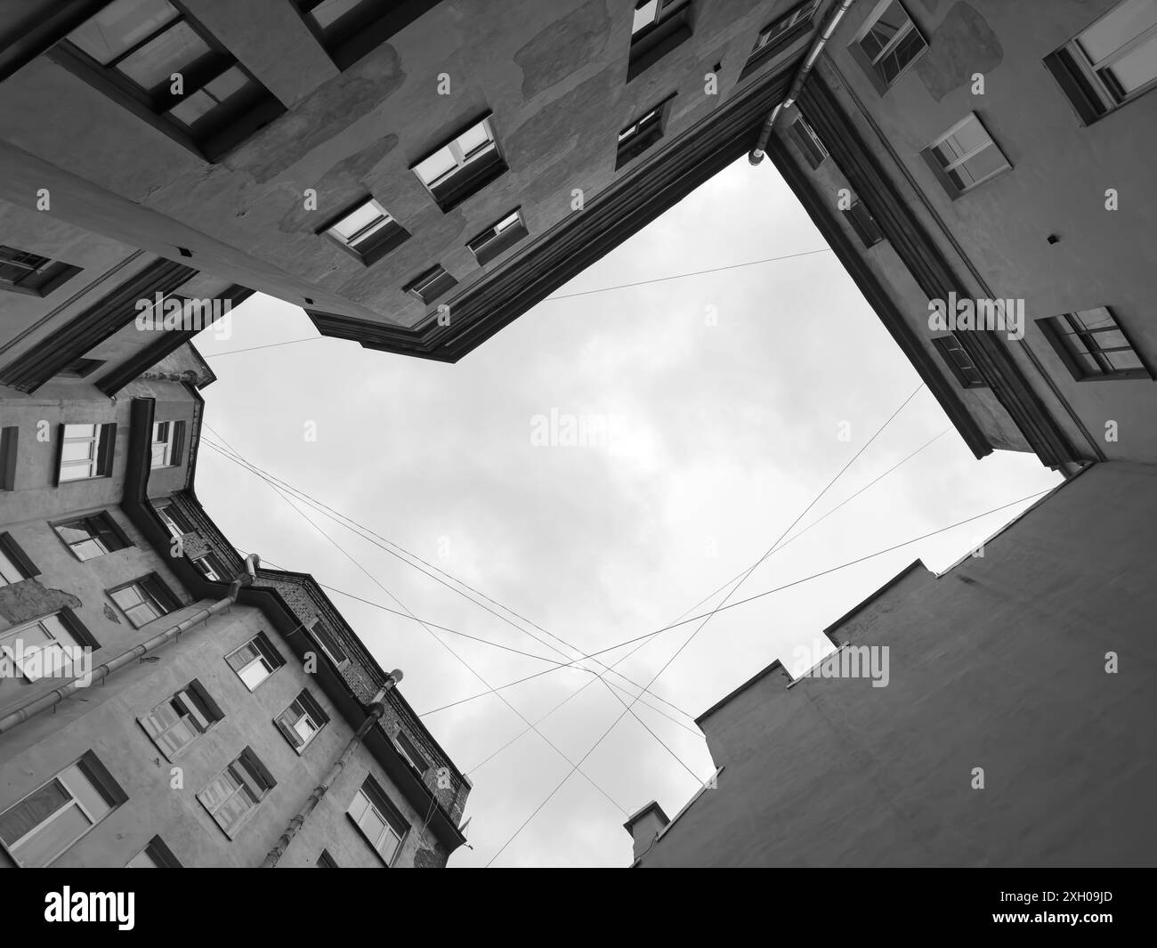 Einfarbiges Bild mit Blick auf eine Gruppe von hohen Stadtgebäuden vom Boden aus, die städtische Architektur und geometrische Linien einfangen. Stockfoto