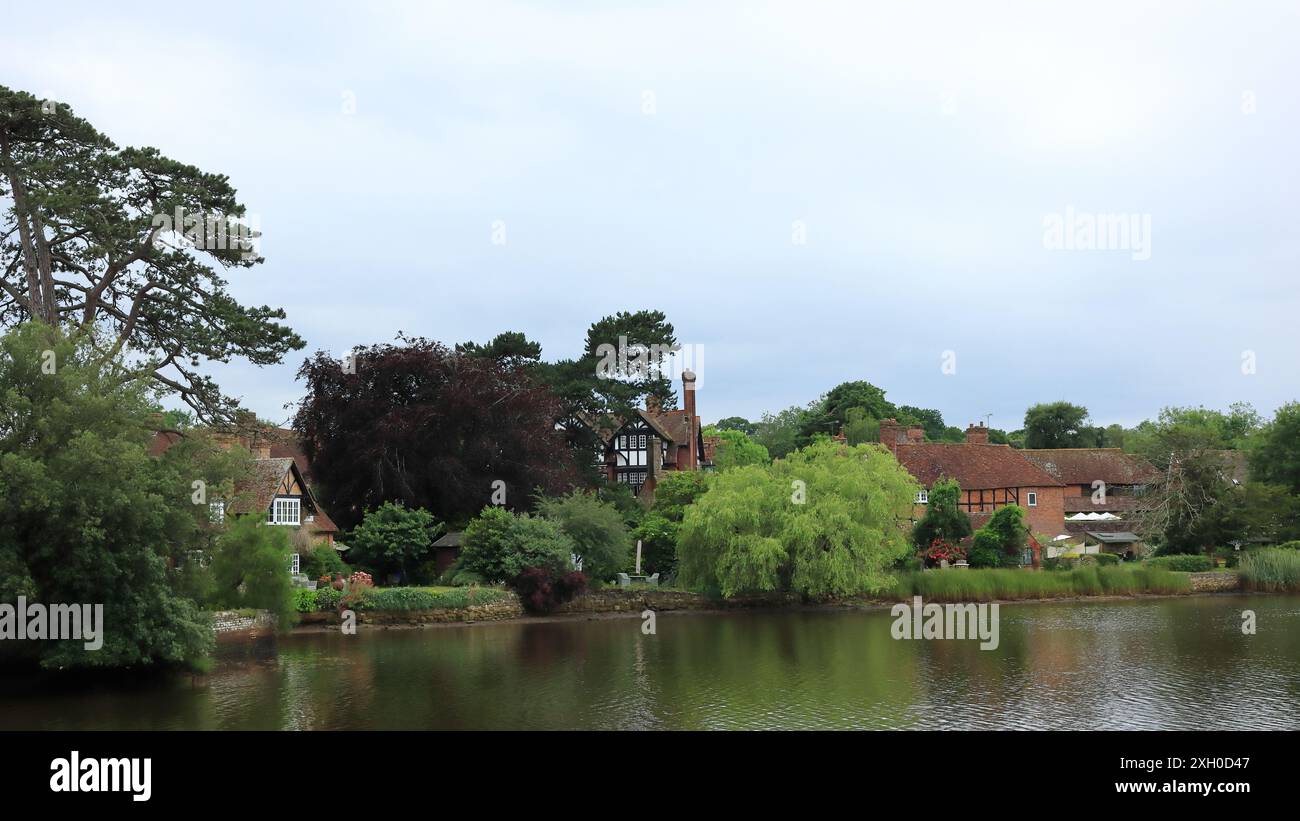 Beaulieu, Brockenhurst, England. 30. Juni 2024. National Motor Museum, Beaulieu. Eine Weitwinkellandschaft des Beaulieu River gesäumt von Bäumen und Häusern. Stockfoto