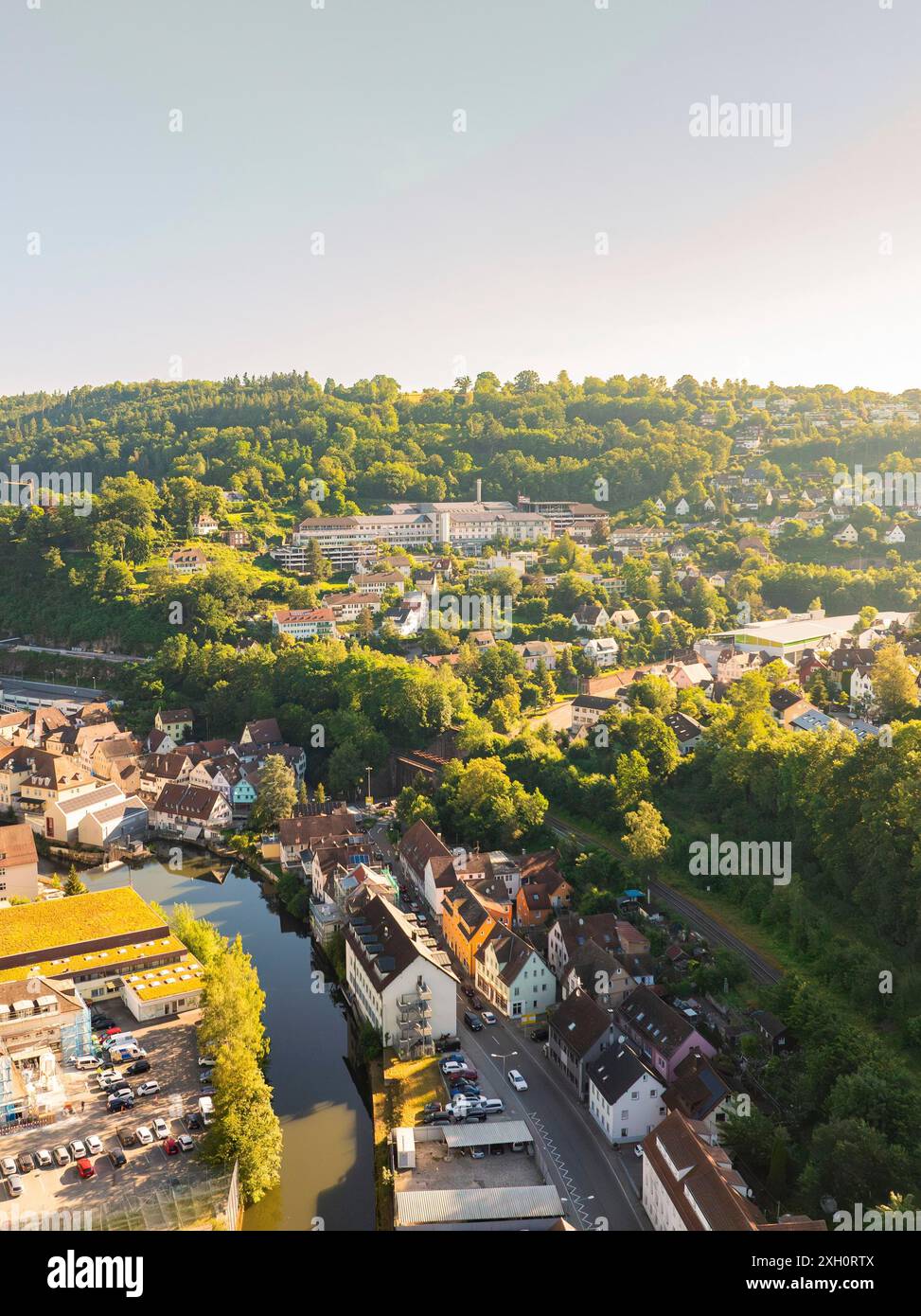 Krankenhaus mit Stadtblick aus der Luft entlang eines Flusses, umgeben von hügeligen Wäldern und Straßen, Calw, Schwarzwald, Deutschland Stockfoto