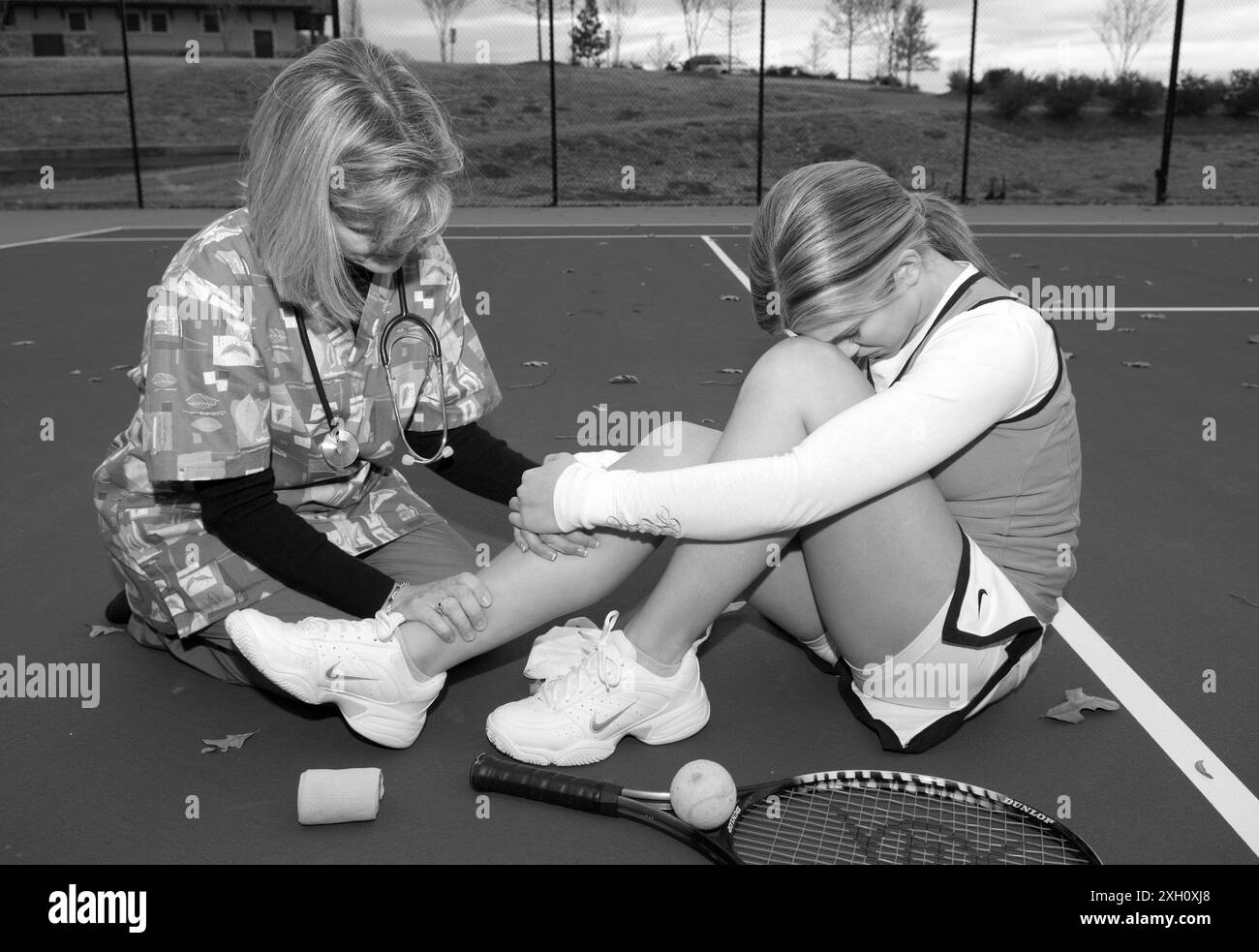 Weibliche Pflegekraft mit einem Stethoskop tröstet kaukasische Teenager-Tennisspielerin. USA Stockfoto