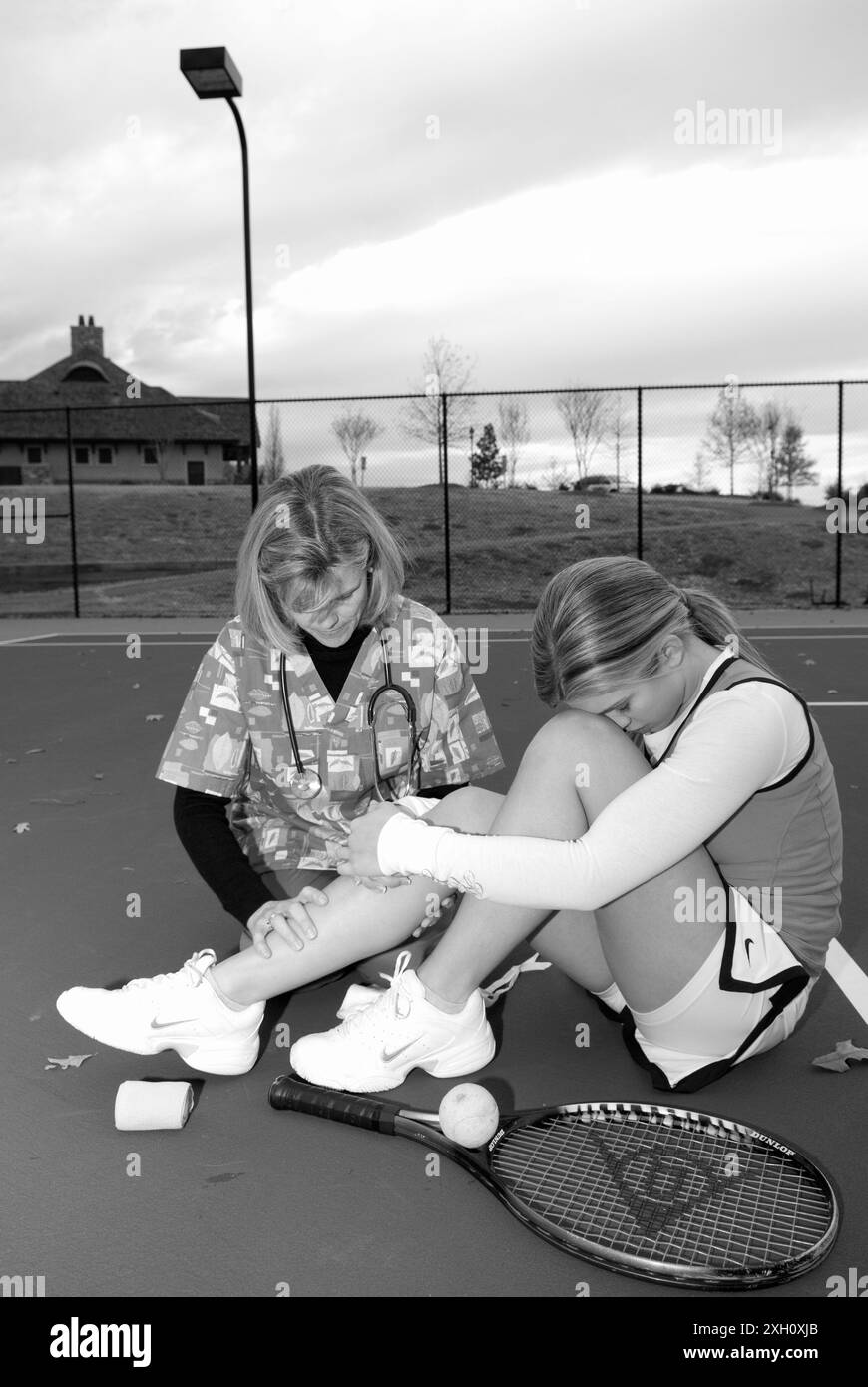 Weibliche Pflegekraft mit einem Stethoskop tröstet kaukasische Teenager-Tennisspielerin. USA Stockfoto