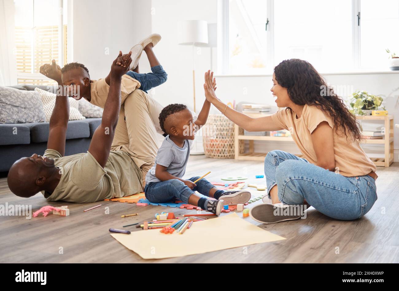 Black Family, High Five und Spielerfolg zu Hause, feiern Bildung und Boden für Spiele. Eltern, Kinder und Flugzeug fliegen oder Blöcke, Unterstützung Stockfoto