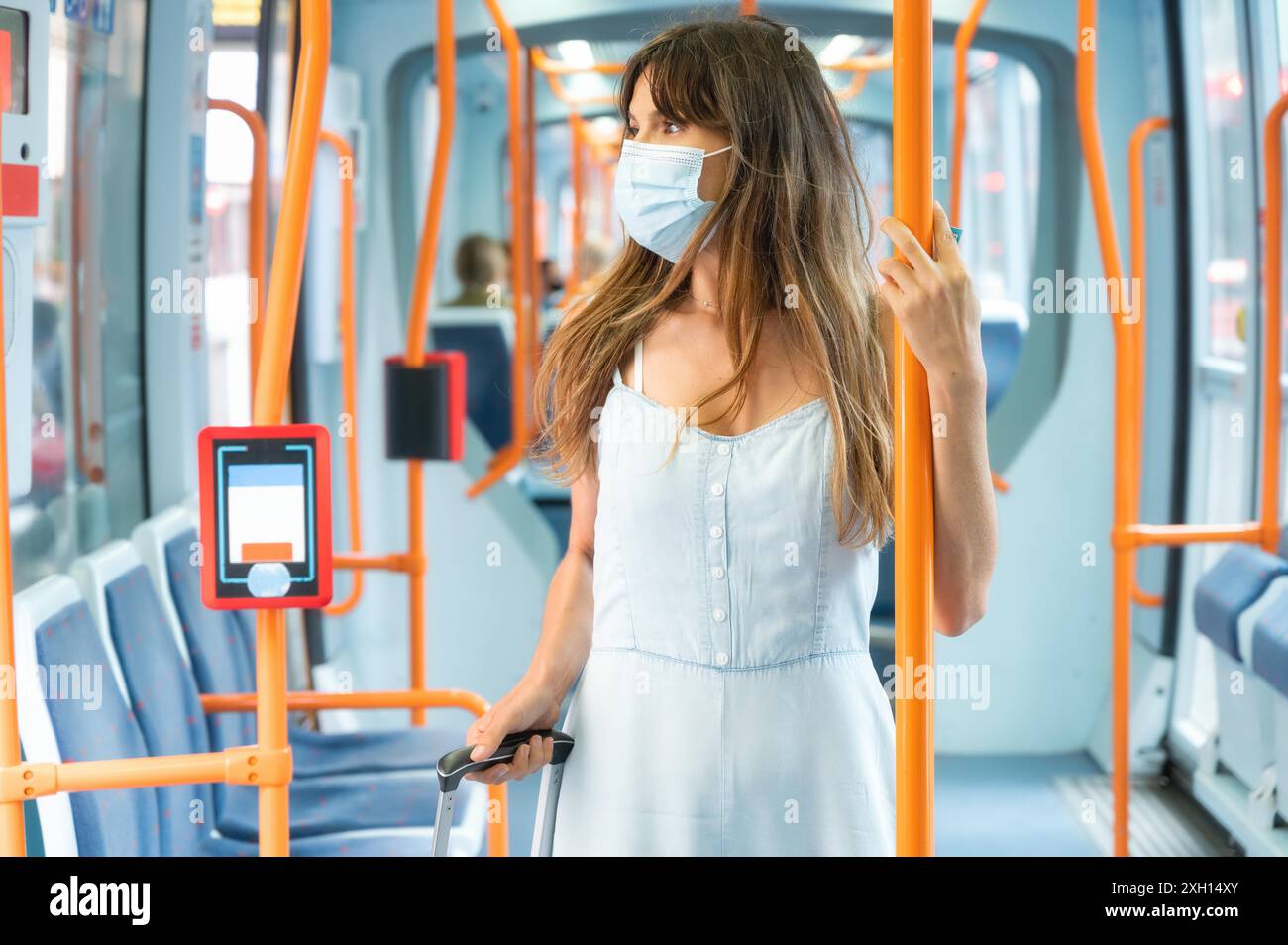 Junge Frau trägt eine Gesichtsmaske Reiten öffentliche Verkehrsmittel. Hochwertige Fotos Stockfoto