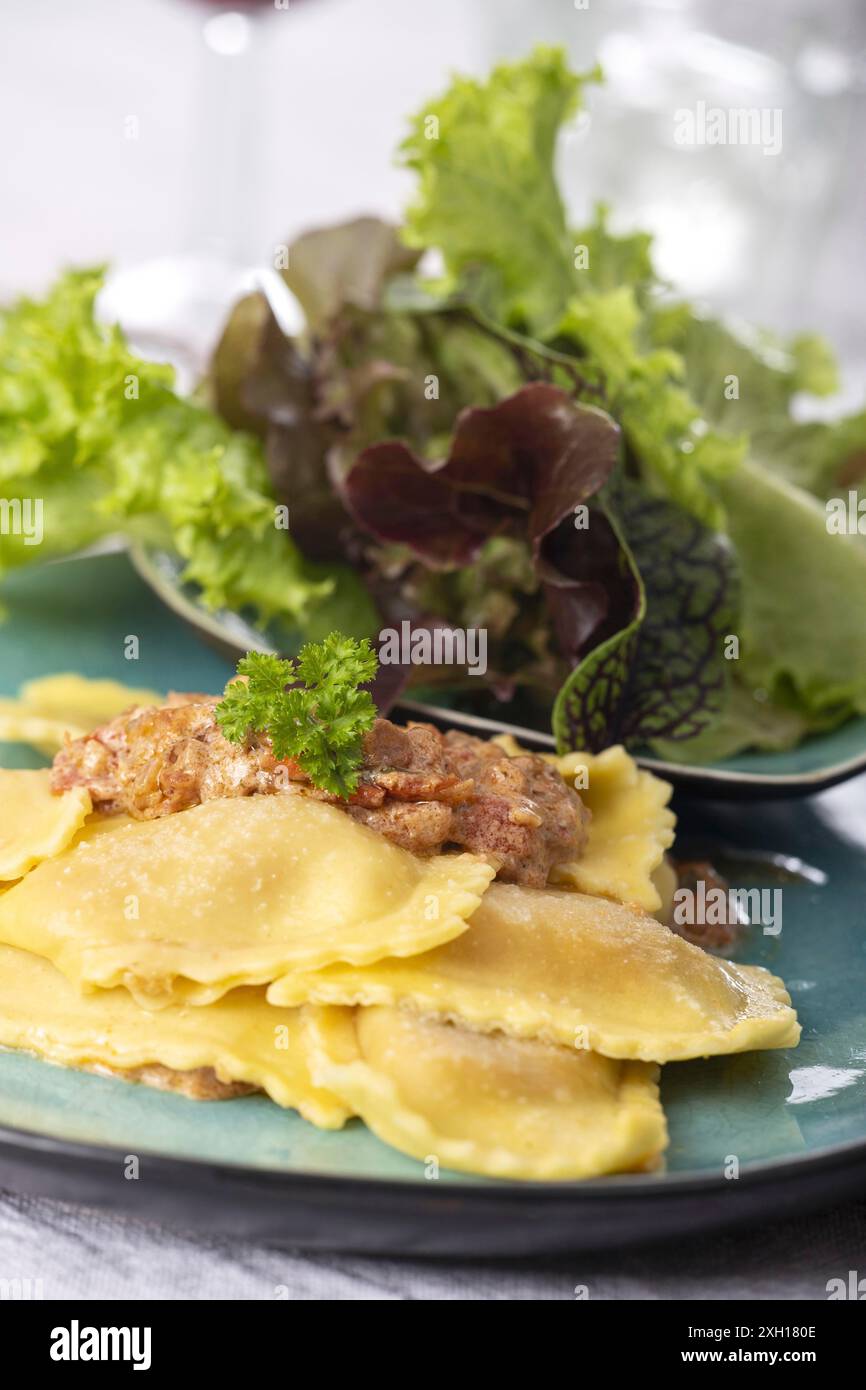 Ravioli mit Sahnesauce und Salat Stockfoto