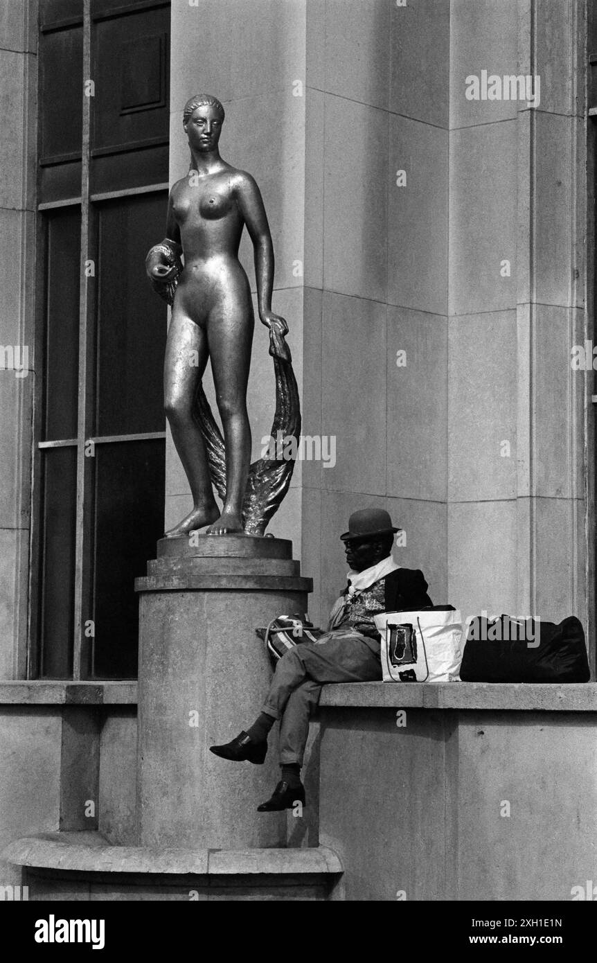 Ein Mann mit Bowler-Hut auf der Trocadero-Esplanade in Paris, September 1991. Flore, eine vergoldete Bronzestatue von Marcel Gimond (1894–1961), die 1937 für die Ausstellung Universelle erworben wurde. Stockfoto