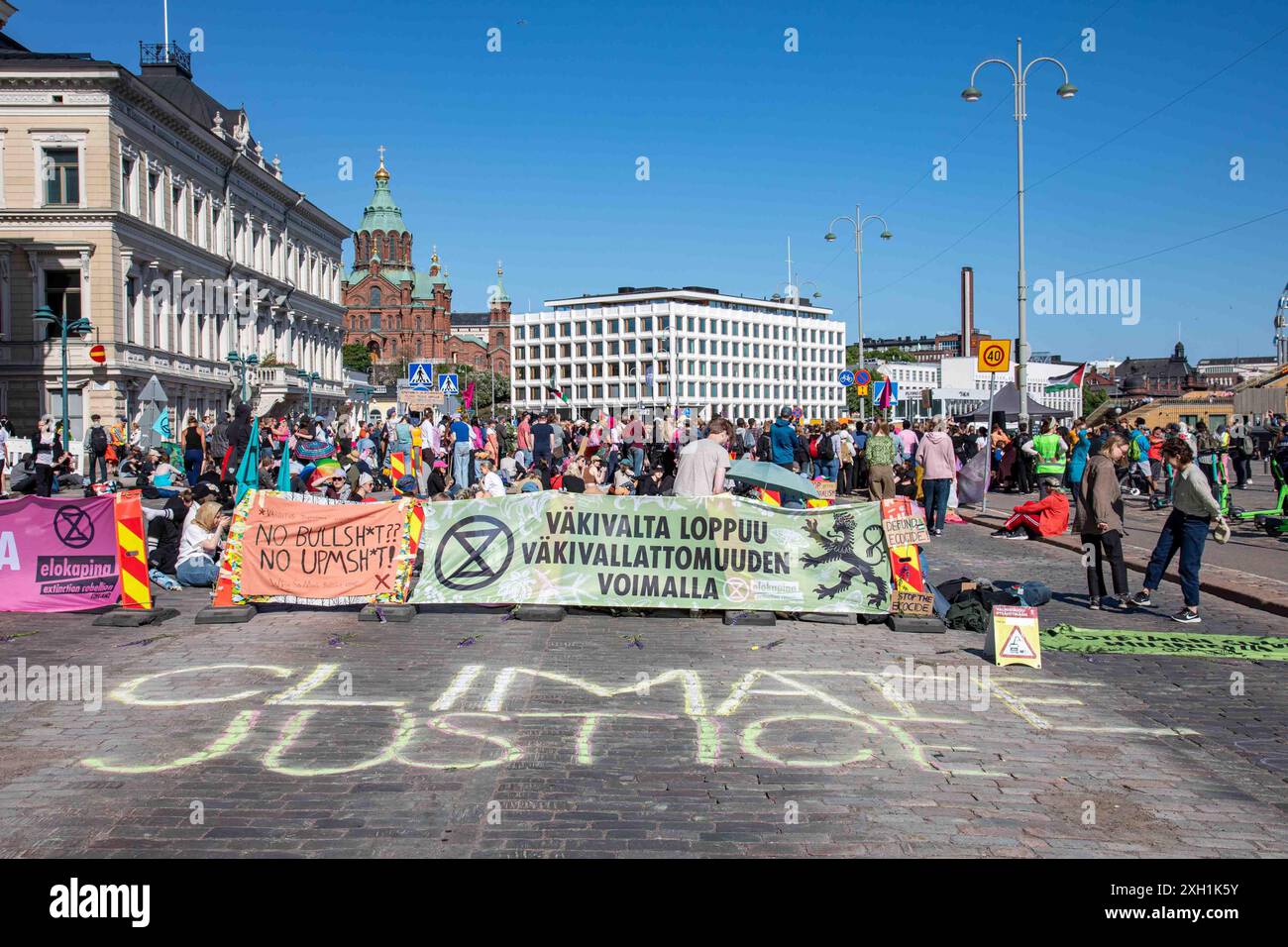 Klimagerechtigkeit. Kreidetext und Banner auf Pohjoisesplanadi bei Elokapinas Myrskyvaroitus 7,6. Straßenbesetzung in Helsinki, Finnland Stockfoto