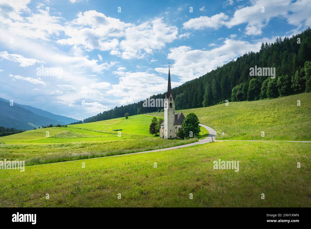 Atemberaubende Aufnahme der Kirche Santa Maddalena di Villabassa, eingebettet in die malerischen Dolomiten, mit ihrer ruhigen Schönheit und majestätischen Kulisse. Stockfoto
