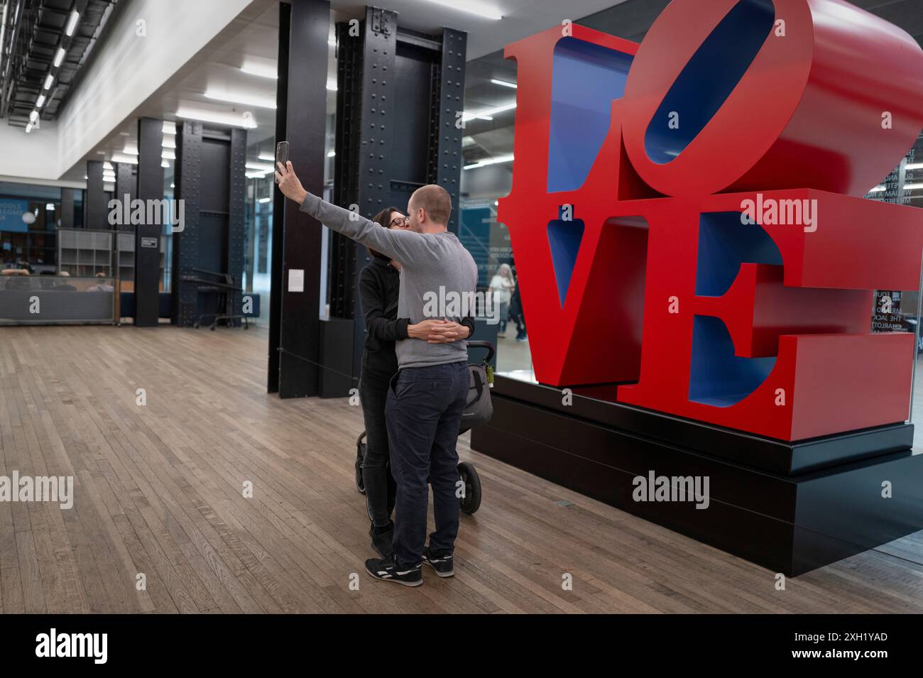 Tate Modern London England Juni 2024 Ein Paar küssen und machen ein Selfie-Bild vor der großen Liebesinstalation 'Love' Sculpture des Künstlers Robert Stockfoto