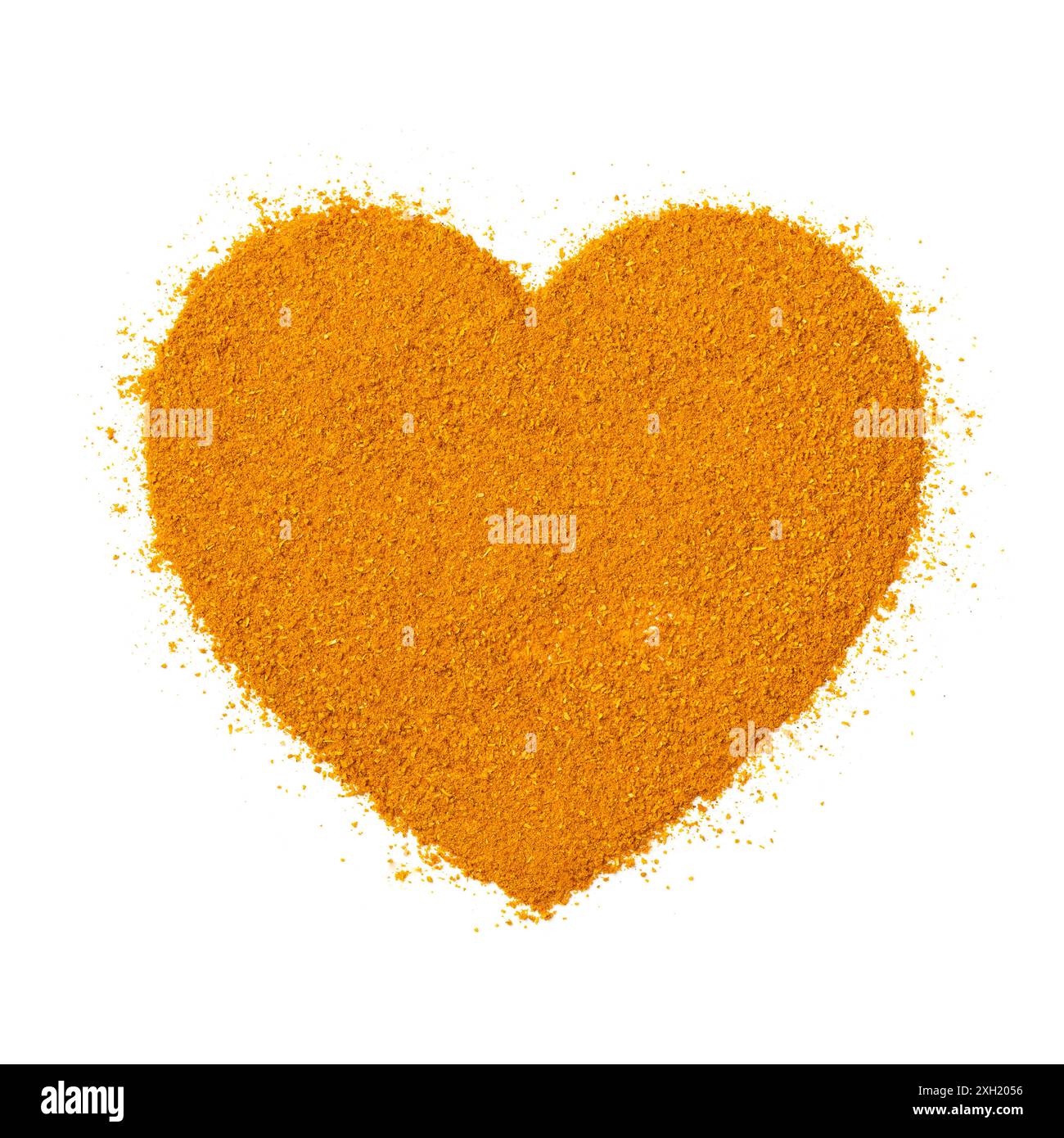 Gelbes indisches Currypulver in Herzform isoliert auf weißem Hintergrund Nahaufnahme Stockfoto