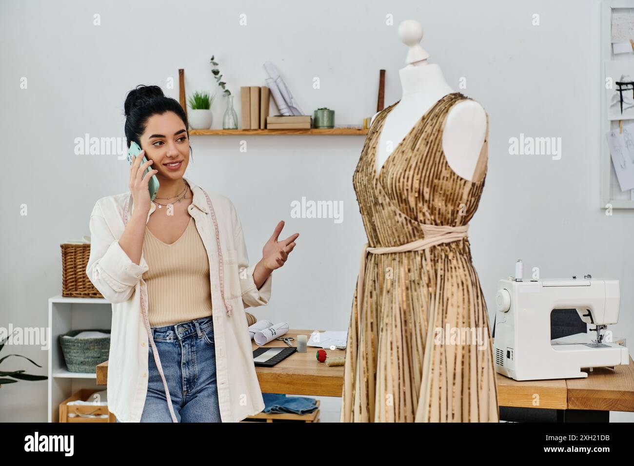 Frau, die neben der Schaufensterpuppe steht und ein Upcycling-Kleid zeigt. Stockfoto