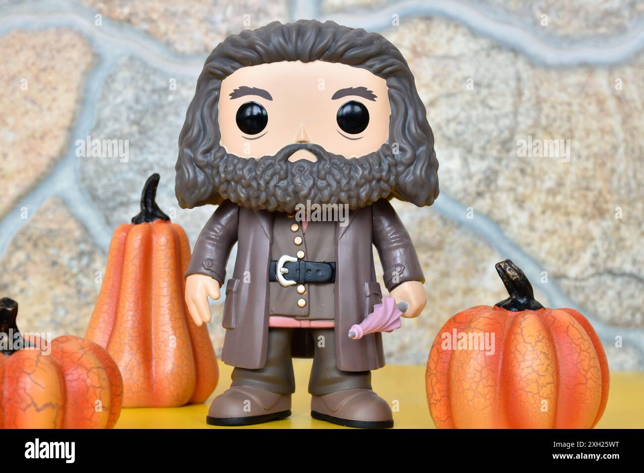 Funko Pop Vinyl-Sammlung Actionfigur des Wildhüters Halbgiganten Hagrid aus dem Fantasy-Film Harry Potter. Steinmauer, Kürbisdekor, gelber Boden. Stockfoto