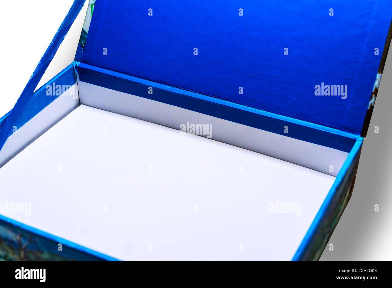 Eine kleine offene Box mit weißem Innenraum und blauem Stoffbezug auf weißem Hintergrund. Stockfoto