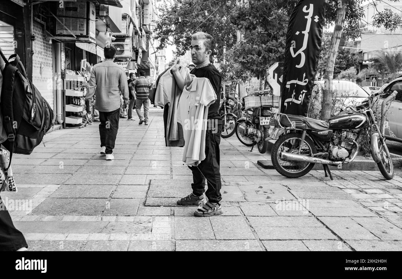 Mann, der T-Shirts auf dem Bürgersteig verkauft. Stockfoto